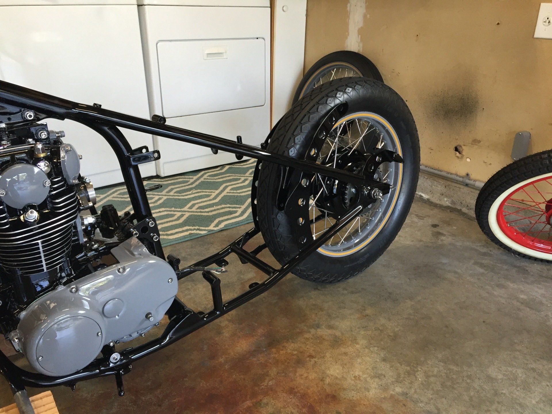 A motorcycle is sitting in a garage next to a washer and dryer.