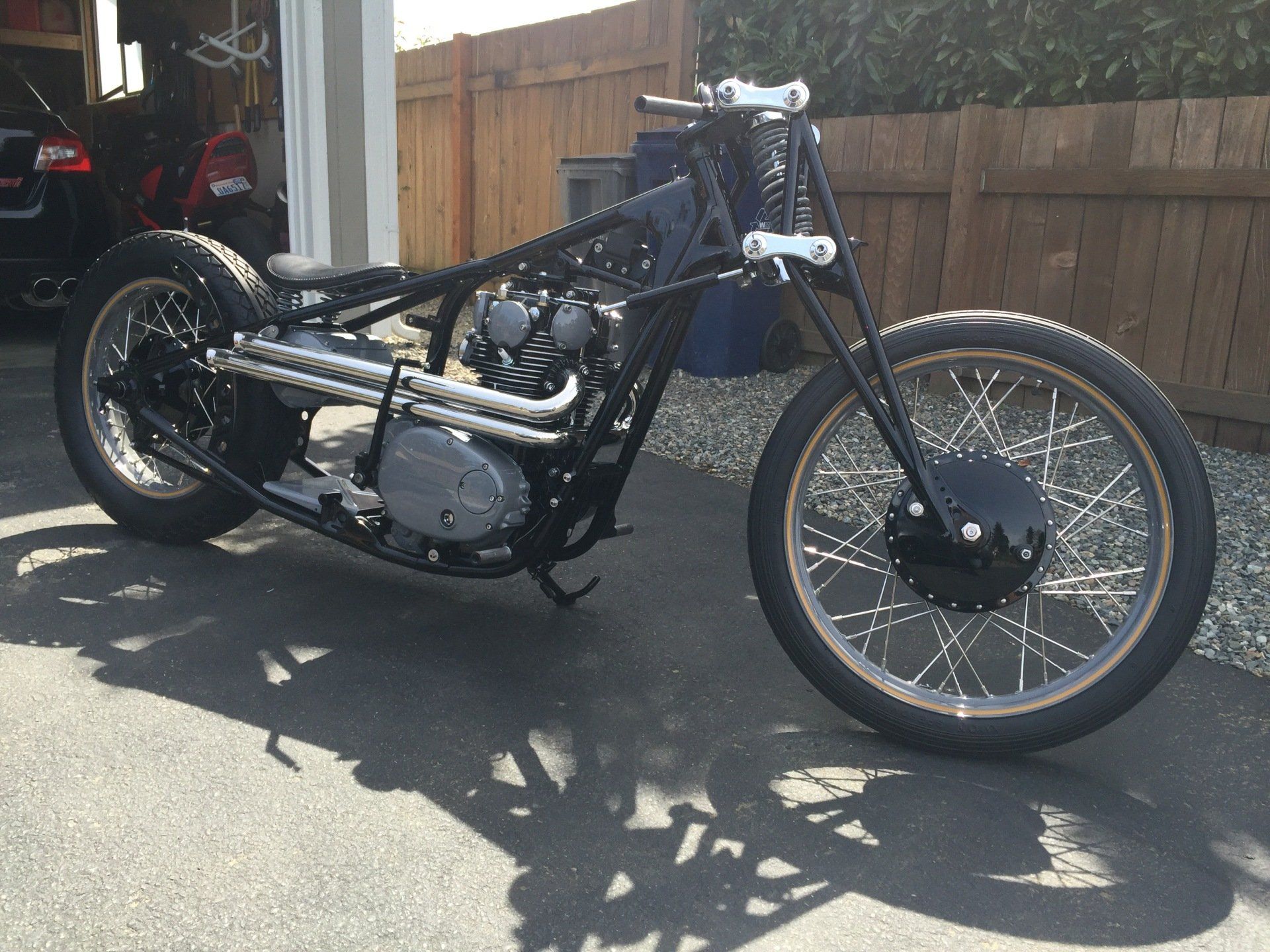 A motorcycle is parked in a driveway in front of a garage.