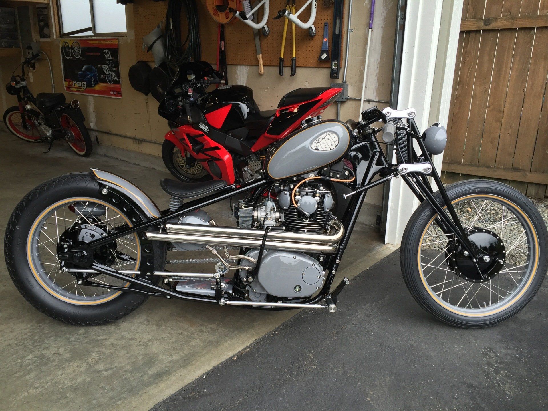 A motorcycle is parked in a garage next to another motorcycle
