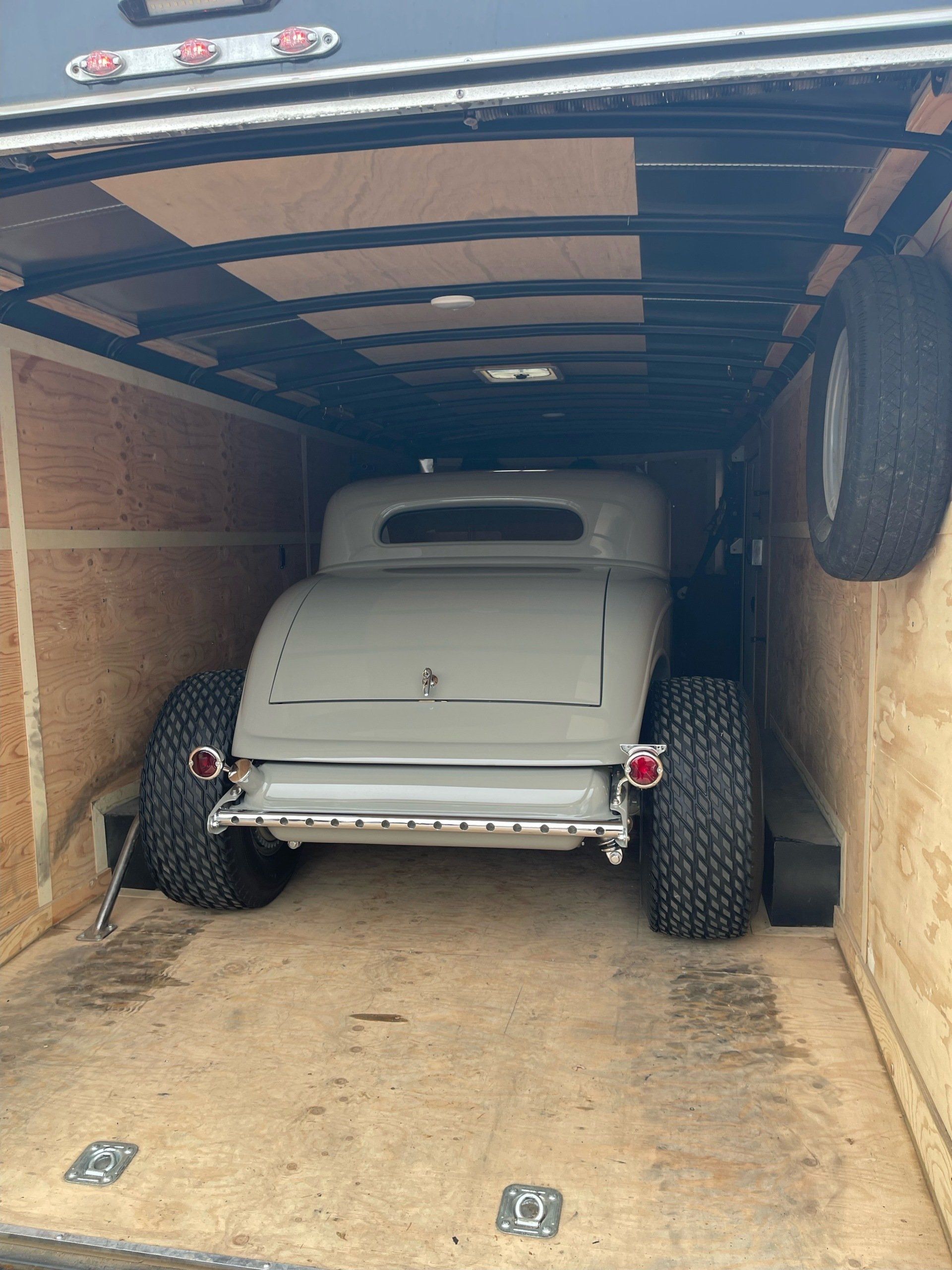 A car is sitting in the back of a trailer.
