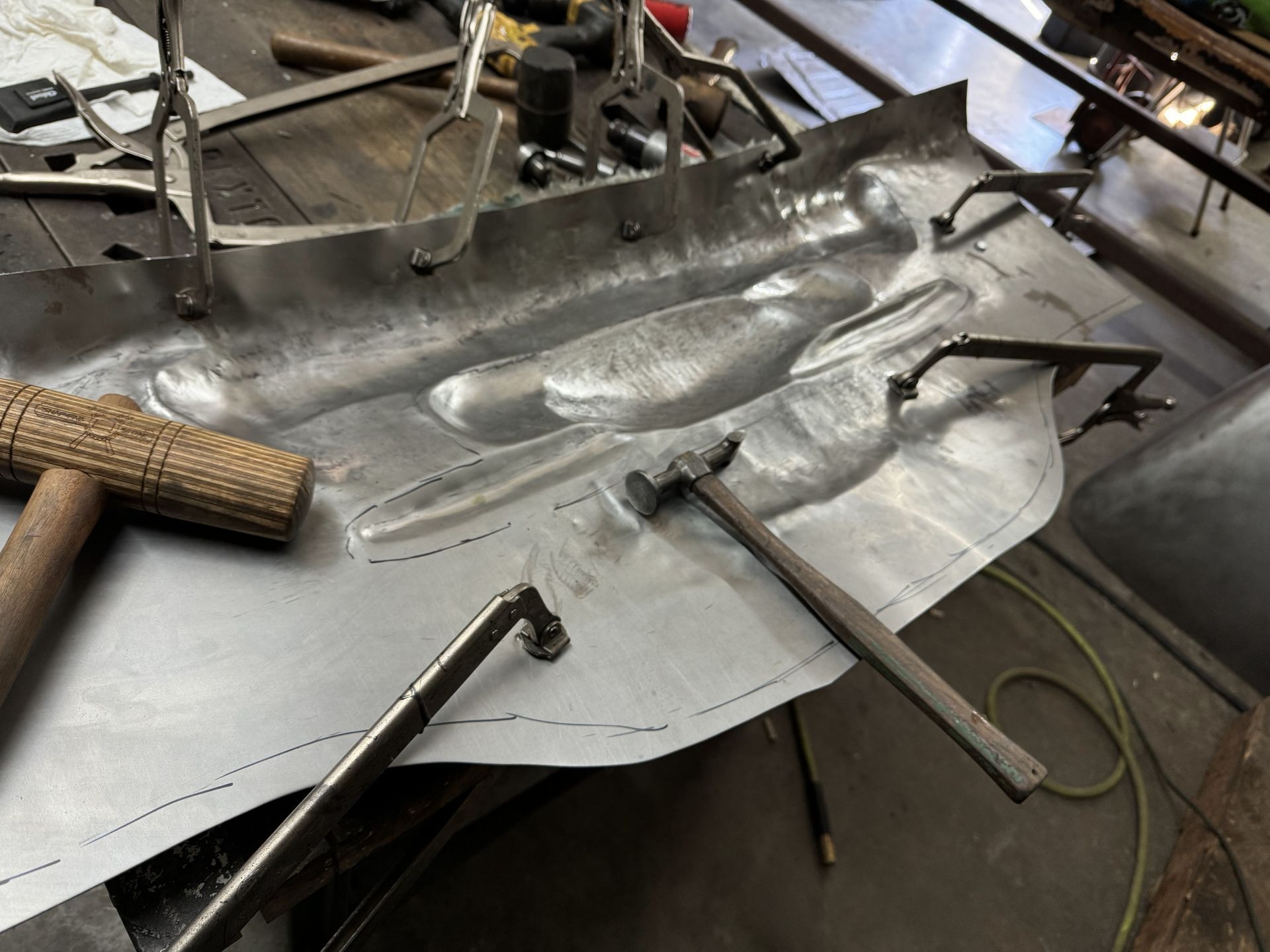 A hammer is laying on a piece of metal on a table