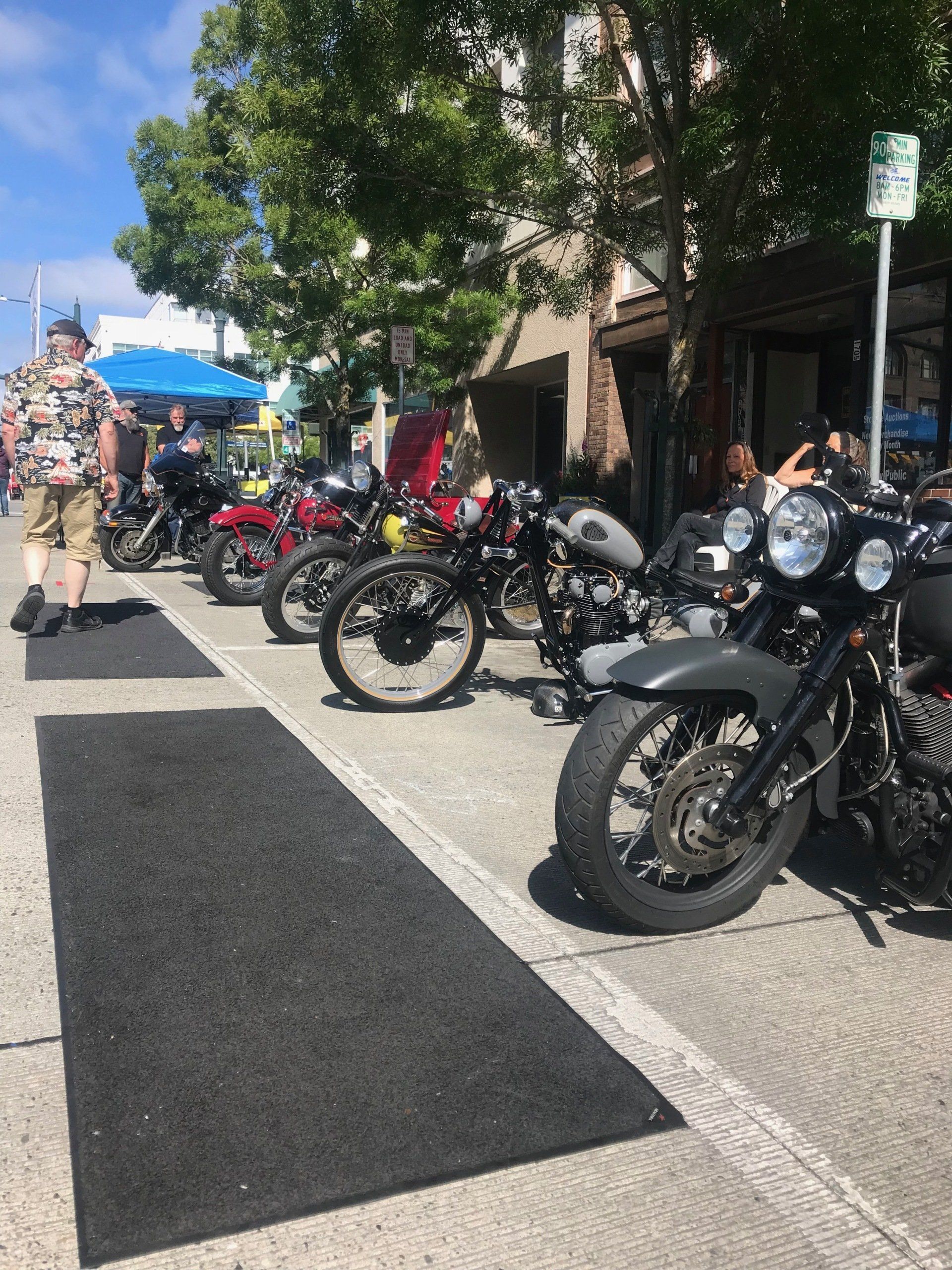 A row of motorcycles are parked on the side of the road