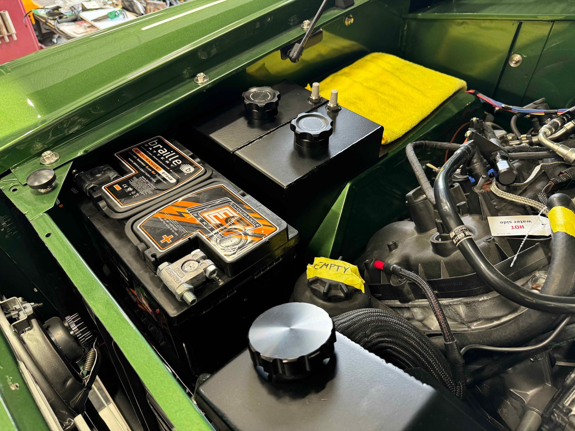 A close up of a car engine with two batteries in it