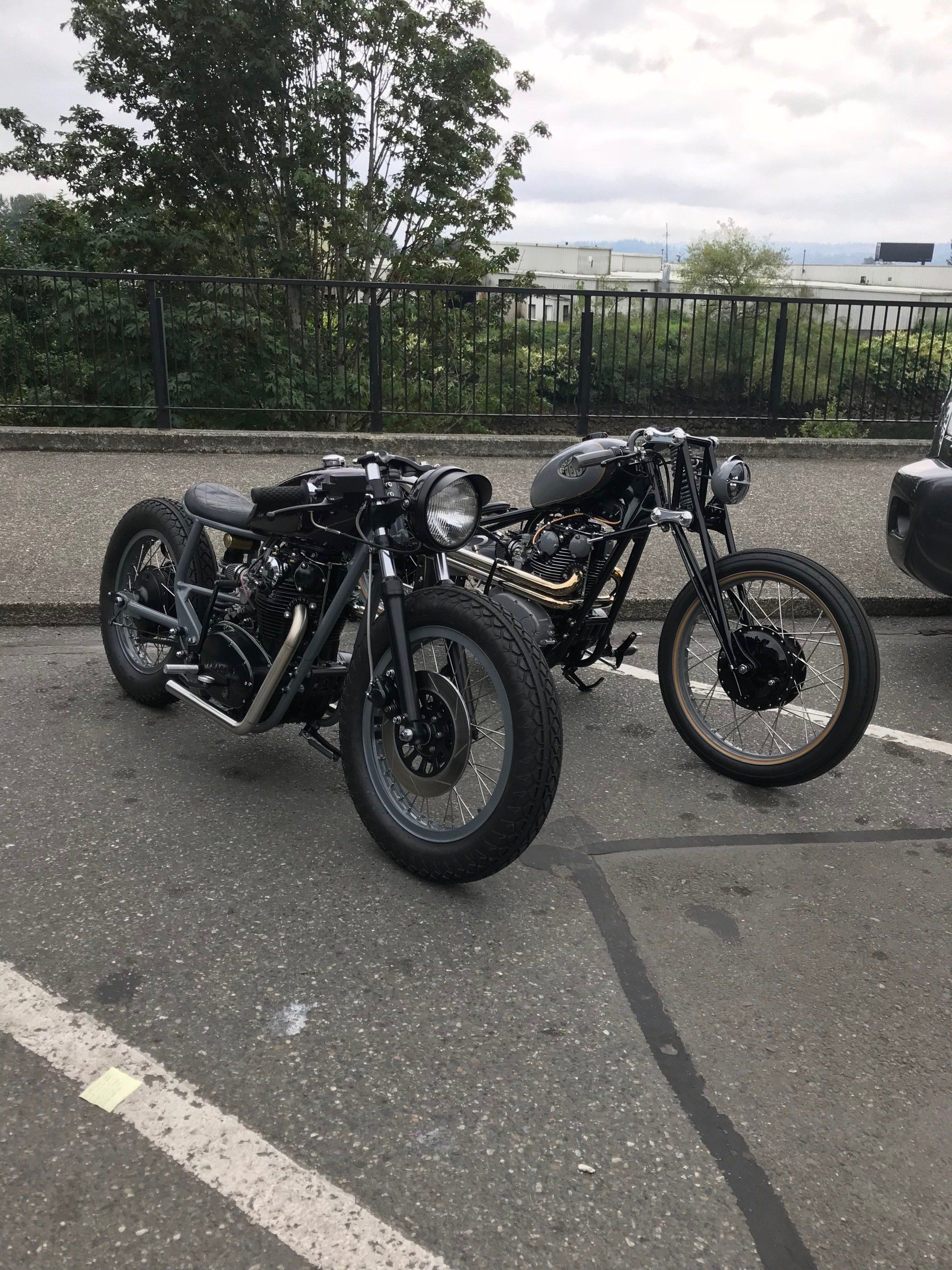 Two motorcycles are parked next to each other in a parking lot.
