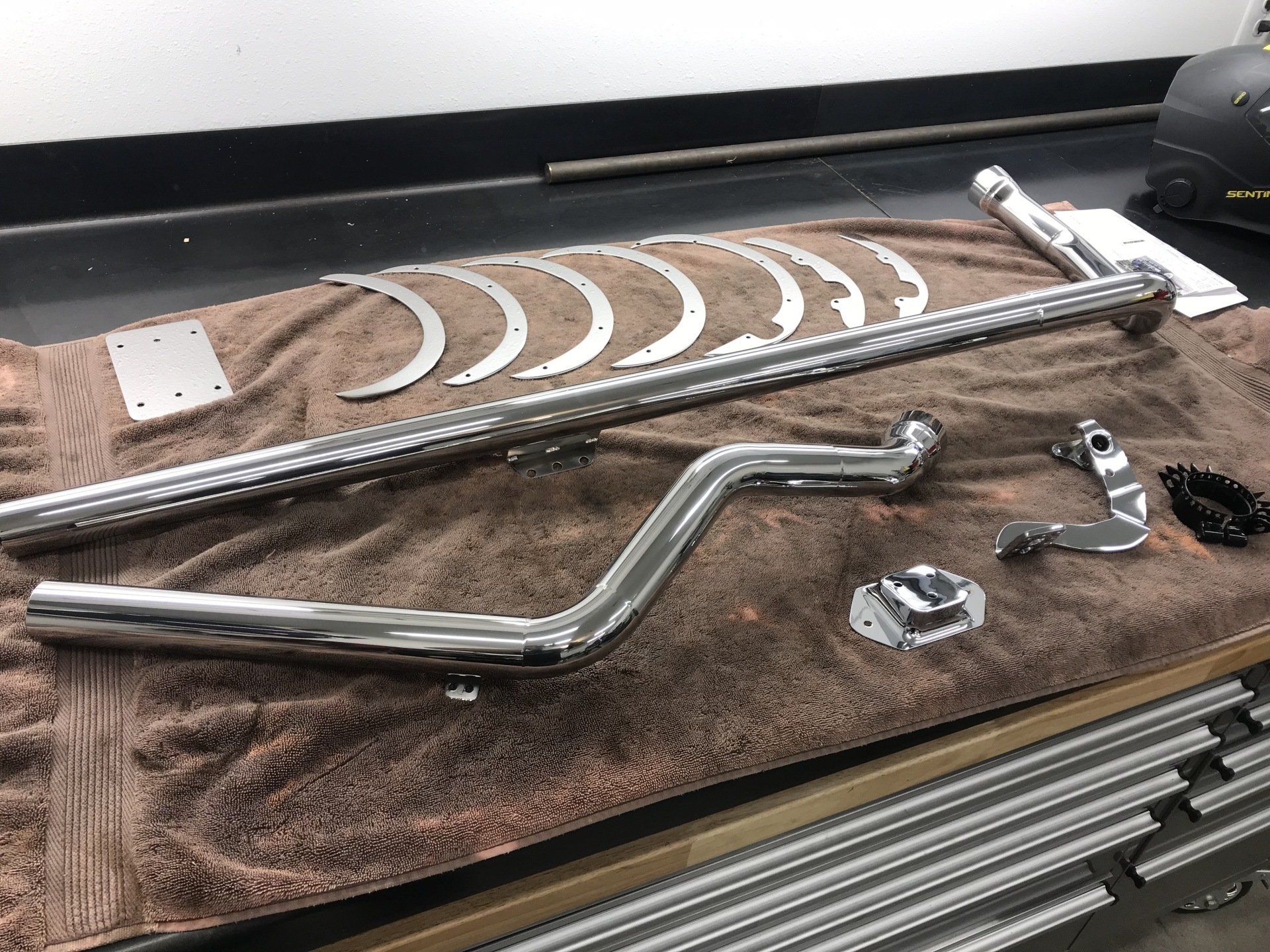A bunch of metal parts are laying on a towel on a table.