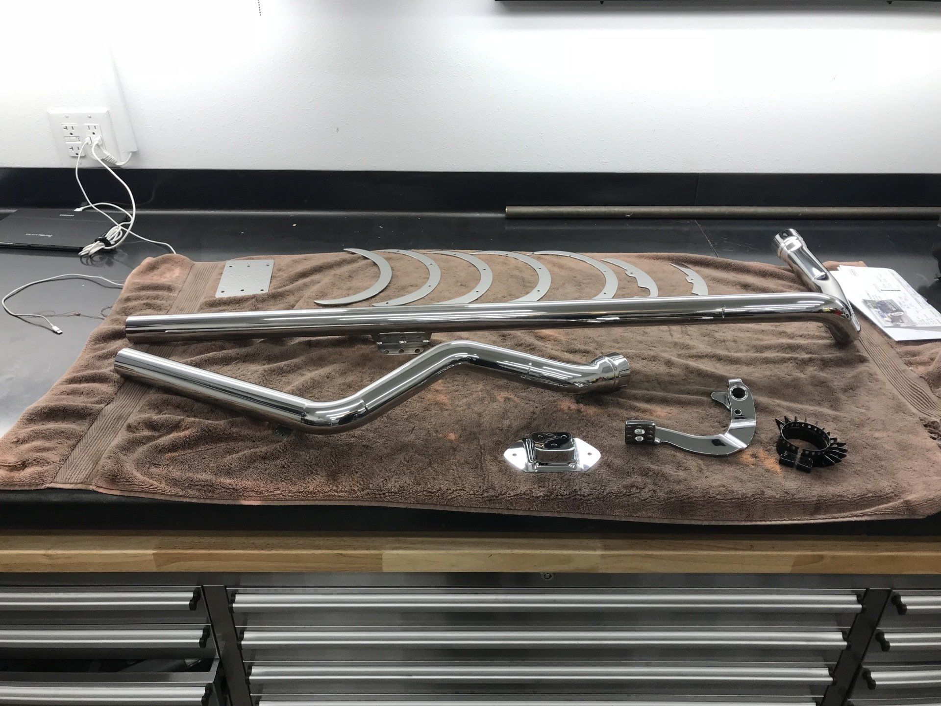 A bunch of metal parts are laying on a towel on a table.