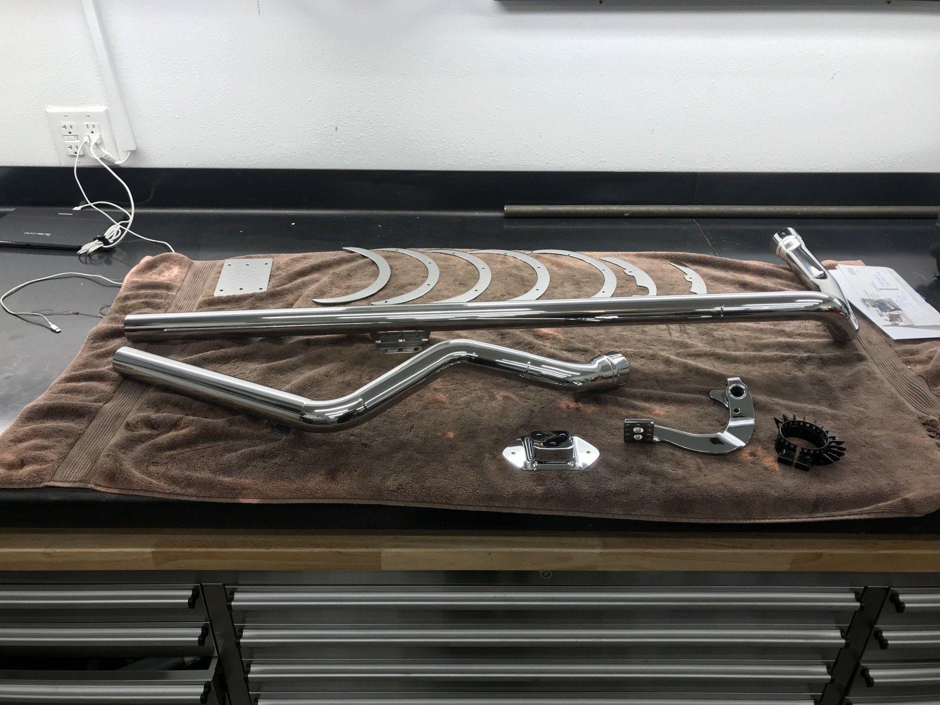 A bunch of metal parts are laying on a towel on a table.