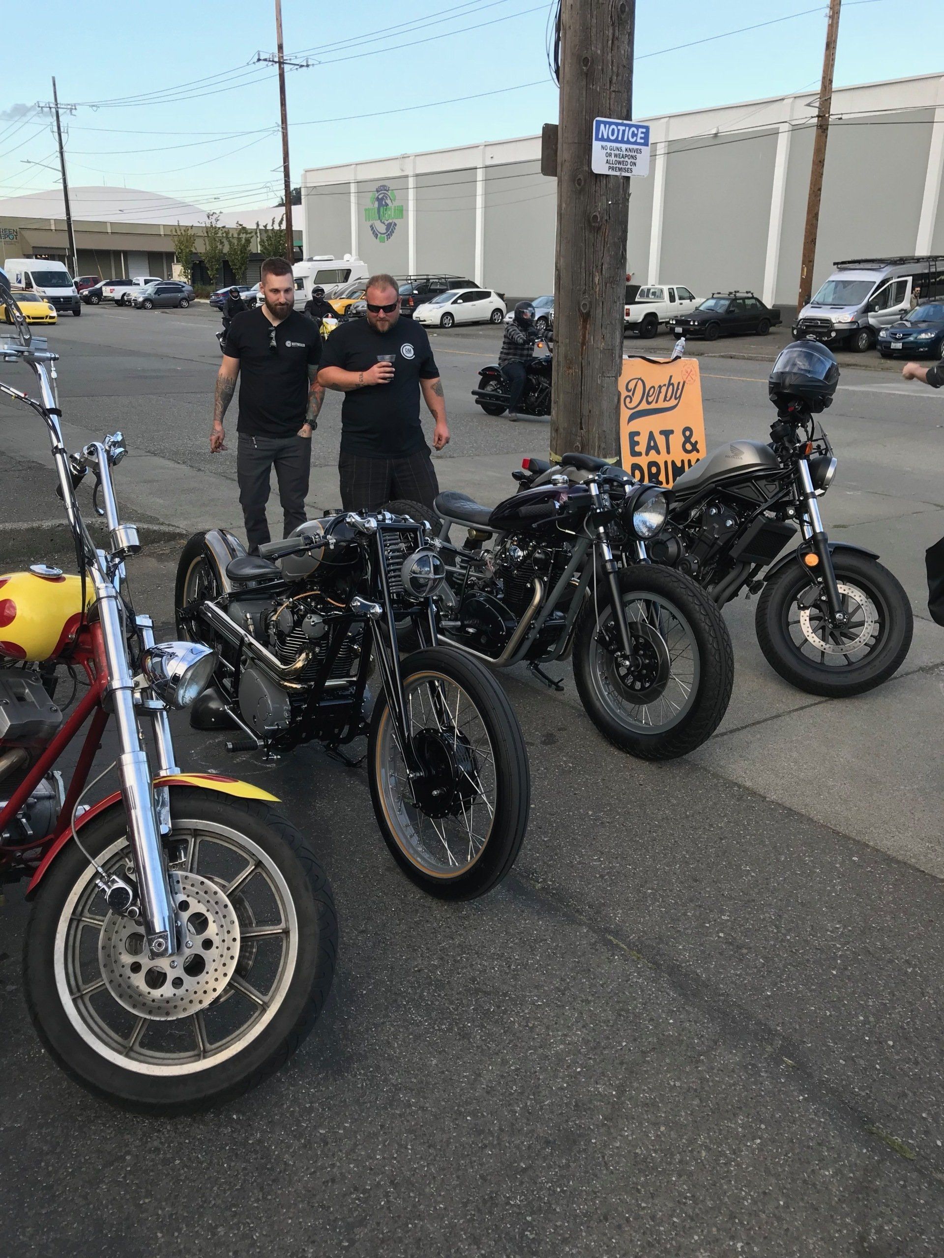 A row of motorcycles are parked next to a sign that says eat & drink