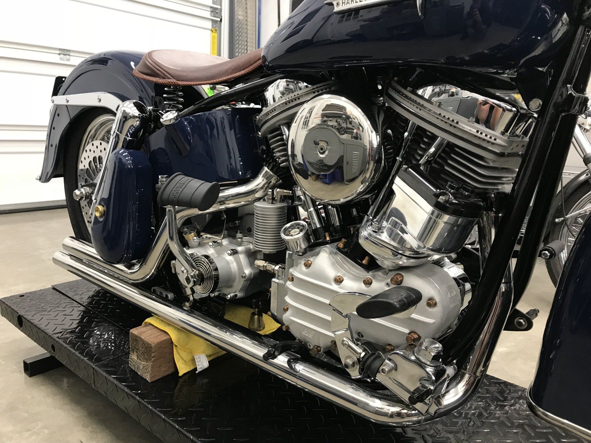 A harley davidson motorcycle is sitting on a lift in a garage.