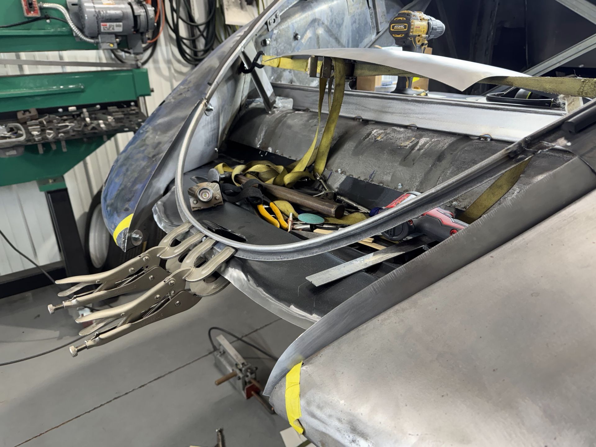 A person is working on a piece of metal in a garage.