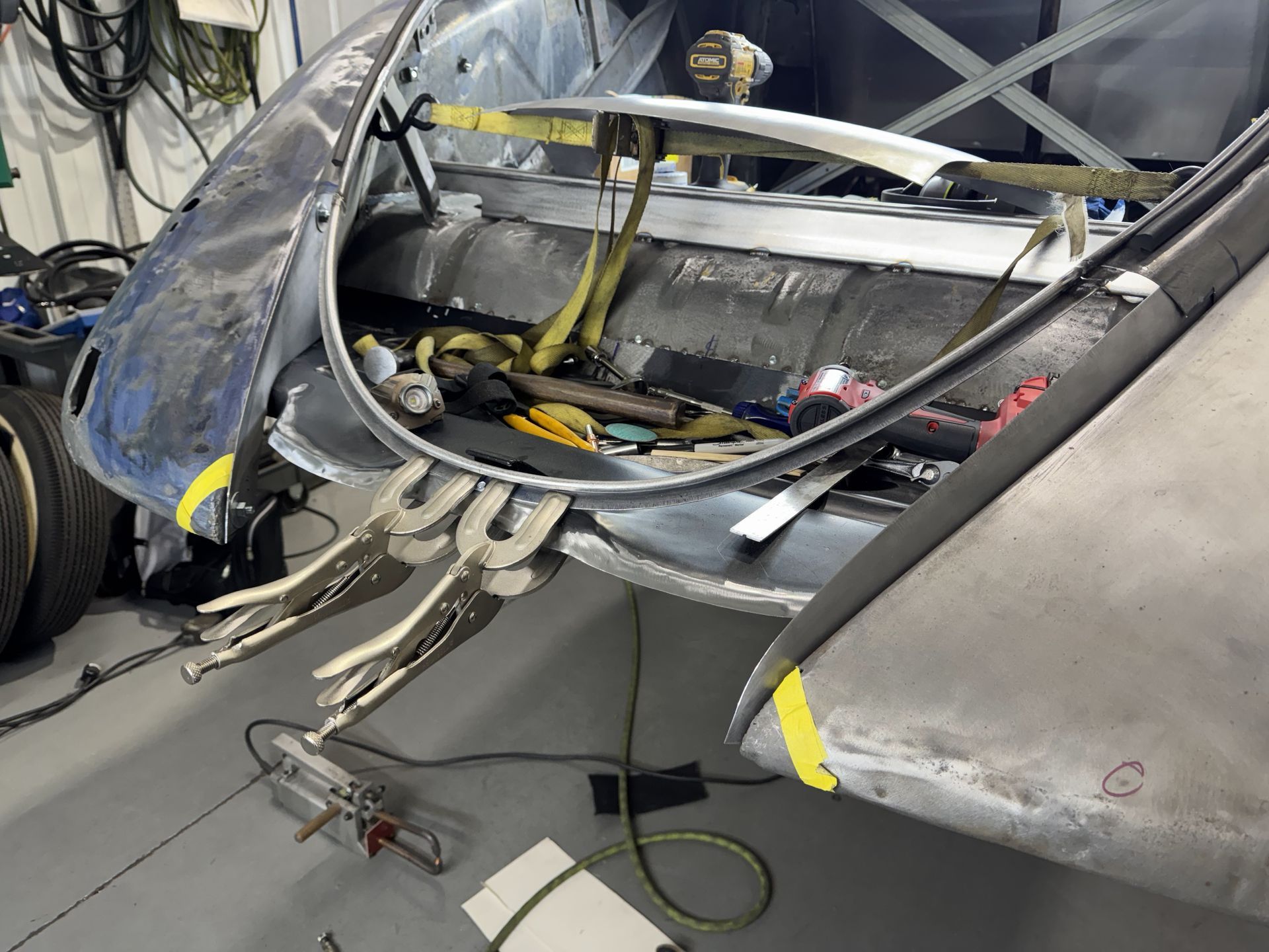 A piece of metal is being worked on in a garage