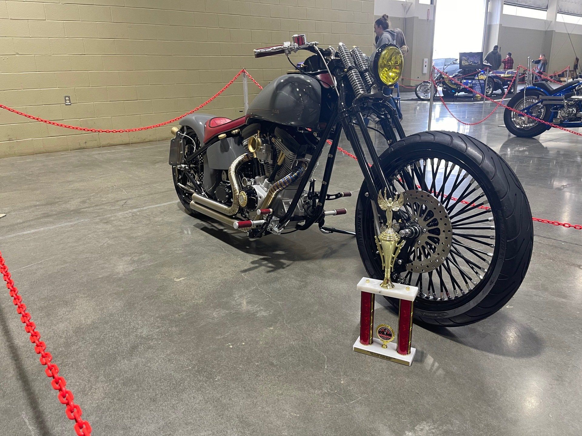 A motorcycle is parked next to a trophy on the floor.