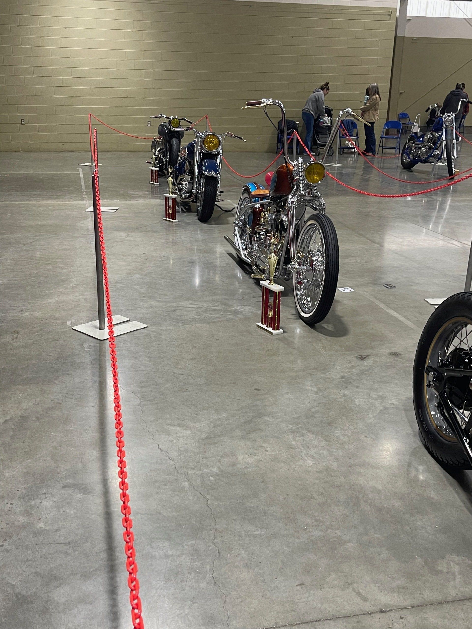 A row of motorcycles are parked in a warehouse.