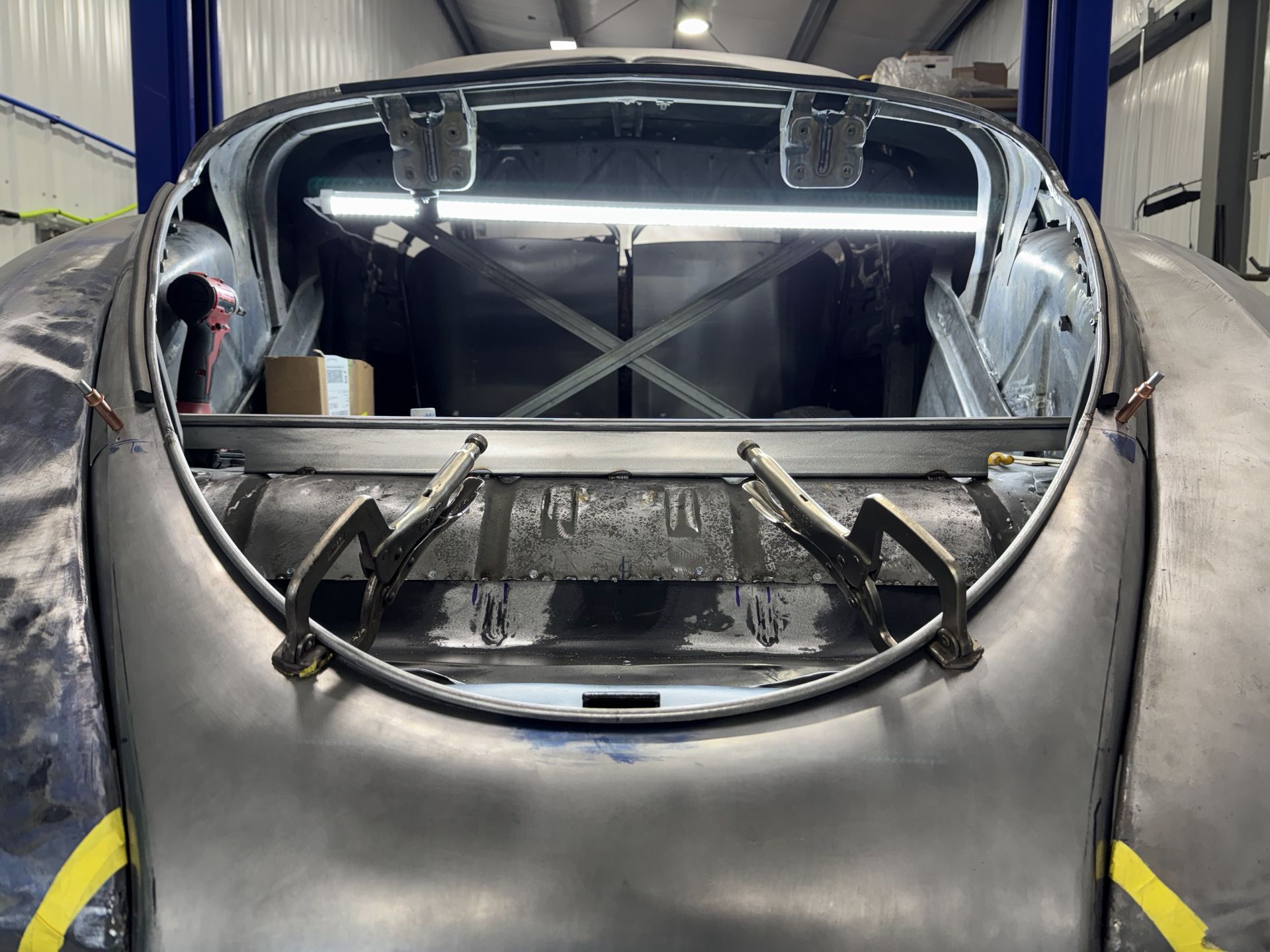 A car is being built in a garage with the hood open