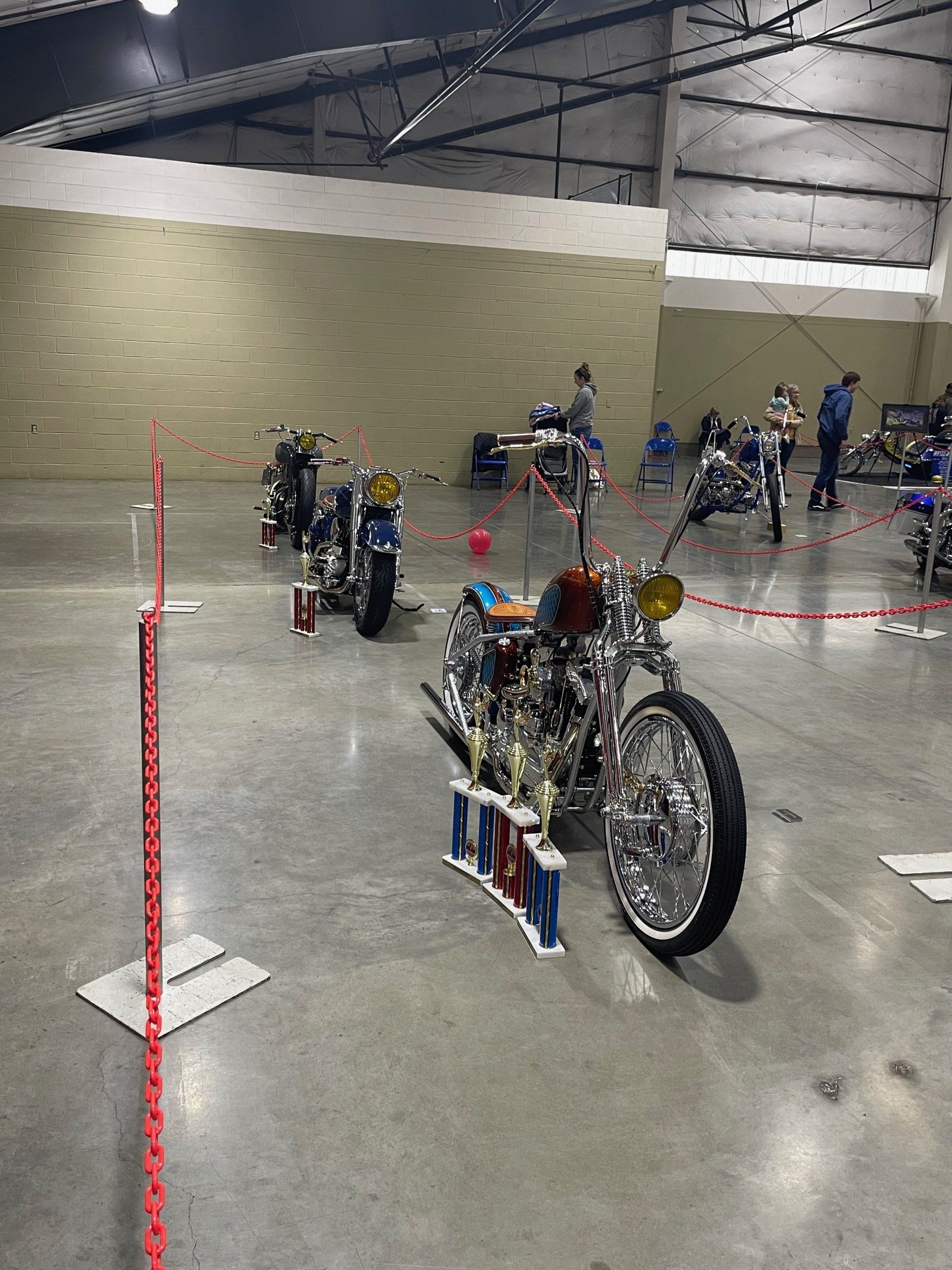 A row of motorcycles are parked in a warehouse.