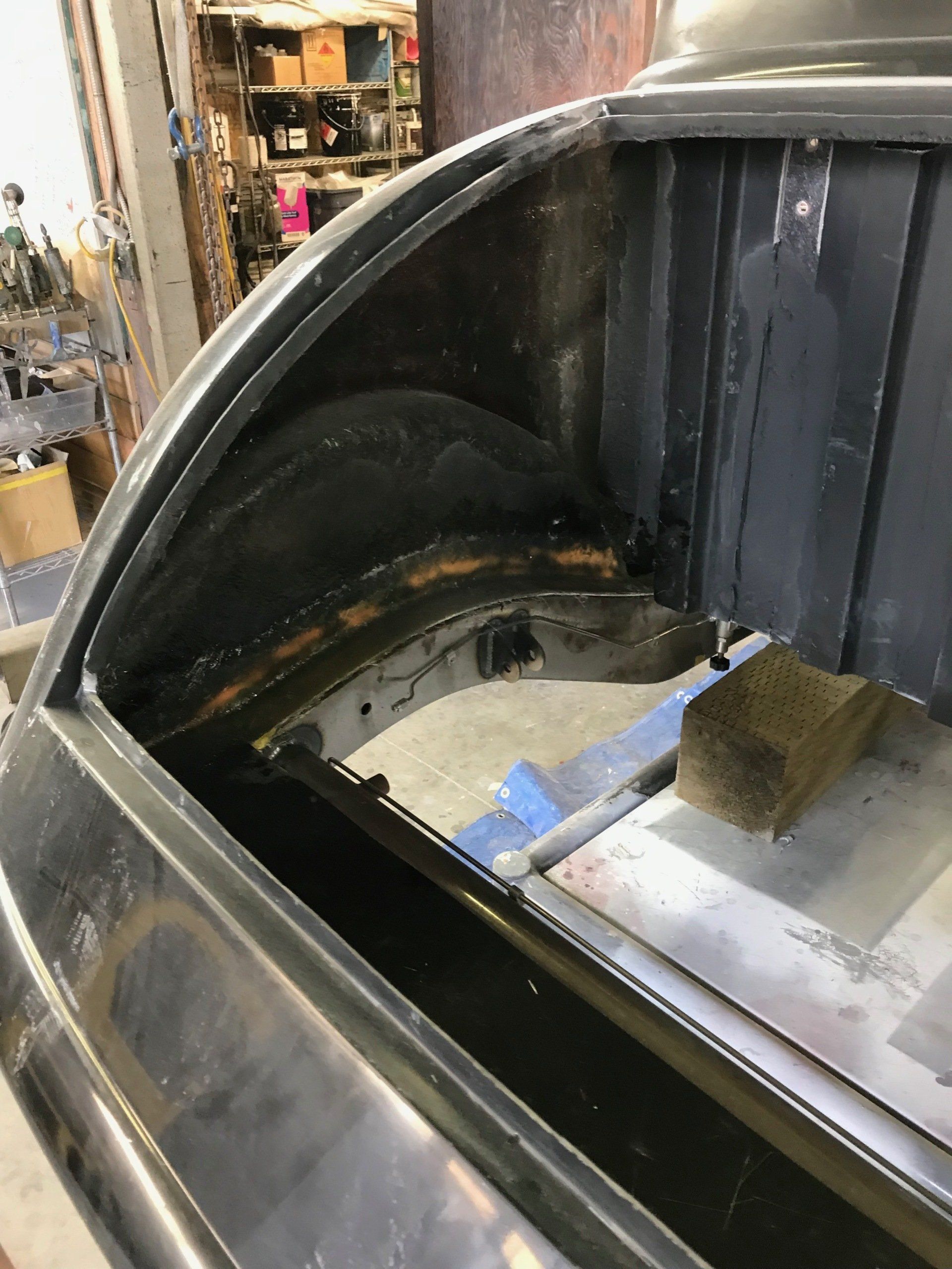 A car is sitting in a garage with the trunk open.