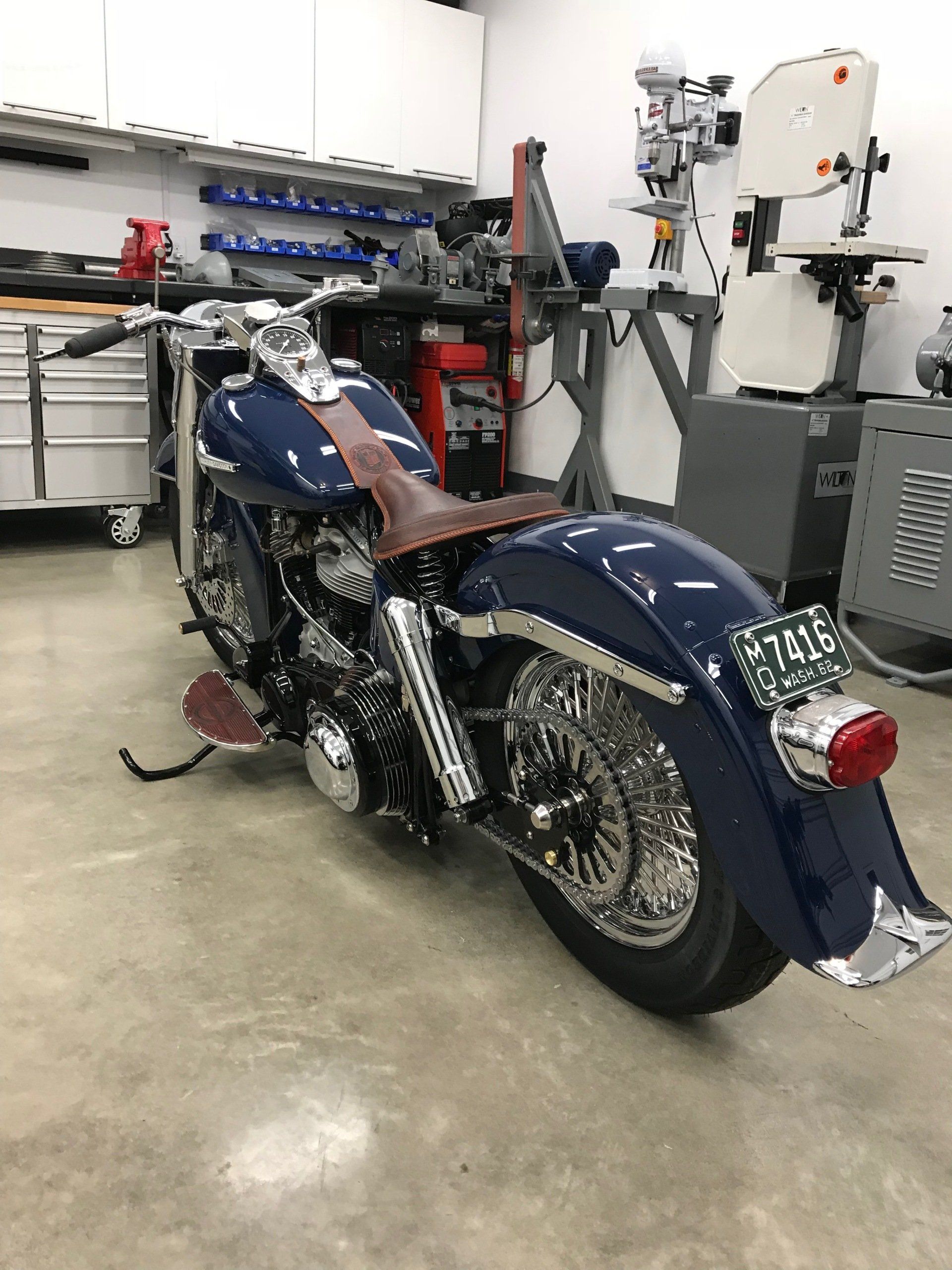 A blue motorcycle is parked in a garage.