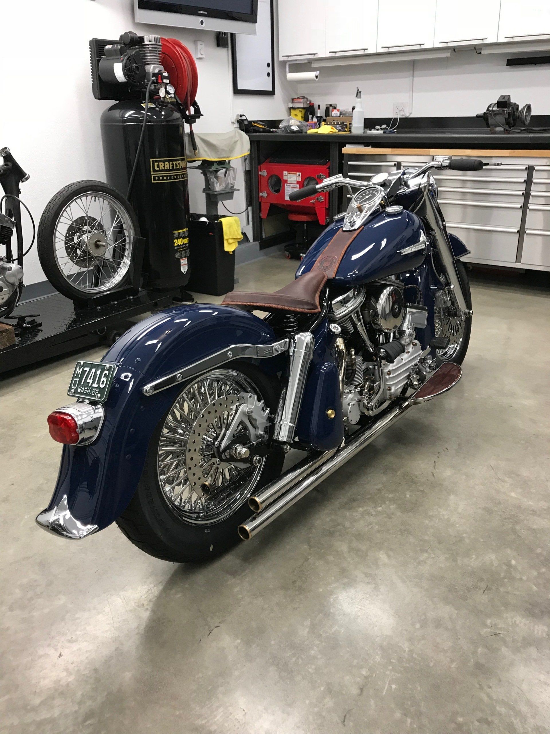 A blue motorcycle is parked in a garage.