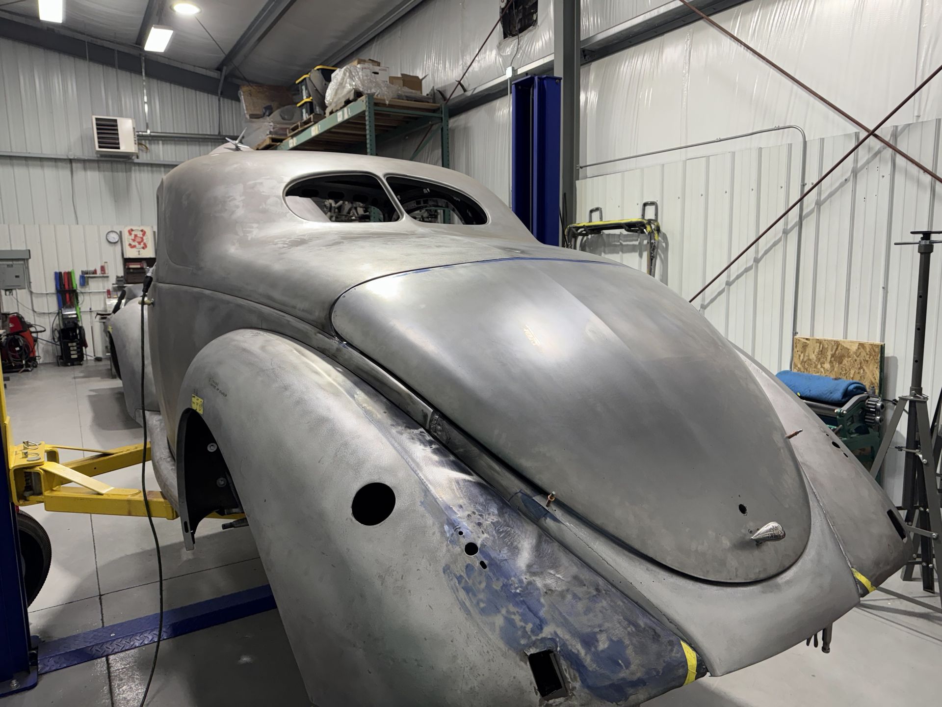 A car is sitting on a lift in a garage.