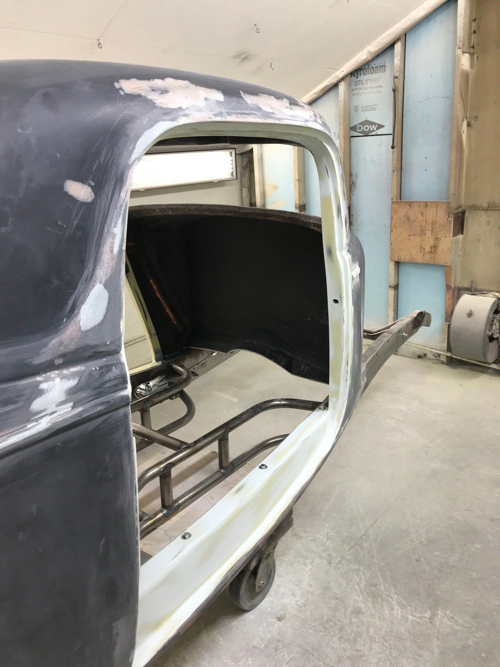 A black car is sitting on a cart in a garage.