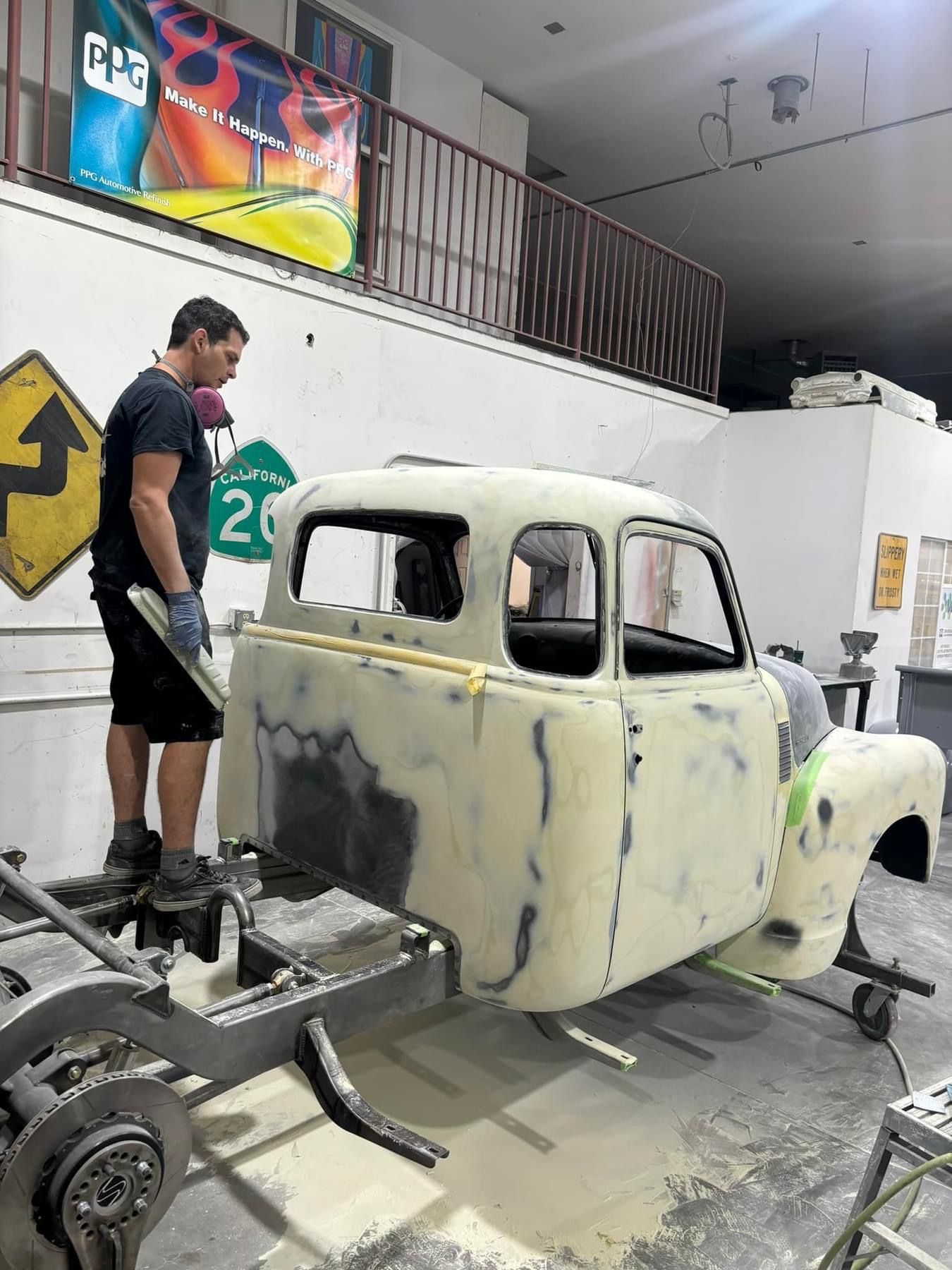 A man is working on a truck in a garage.