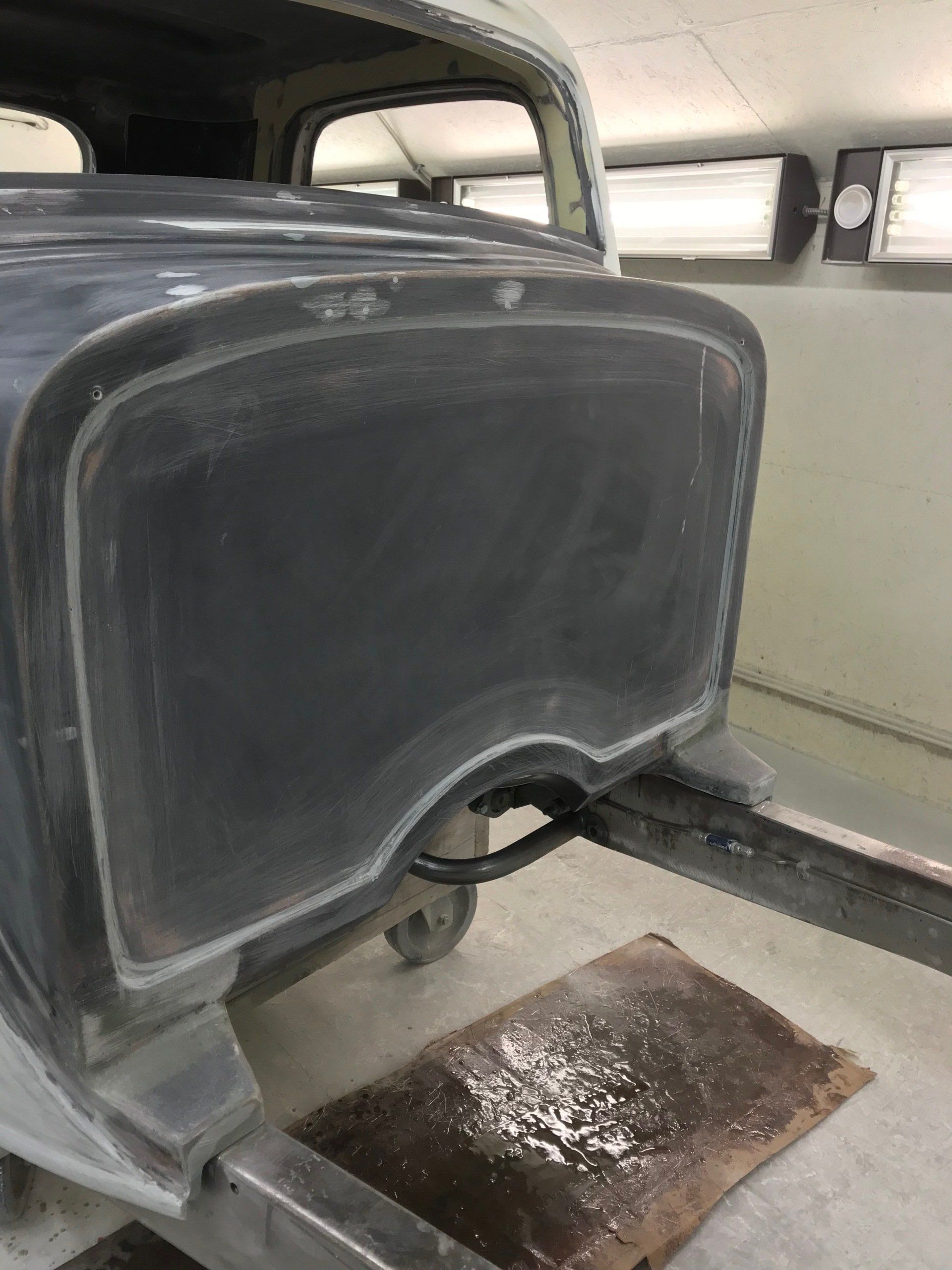 A car is sitting on a lift in a garage.