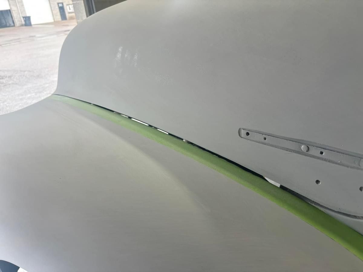 A close up of a white surface with green tape on it.