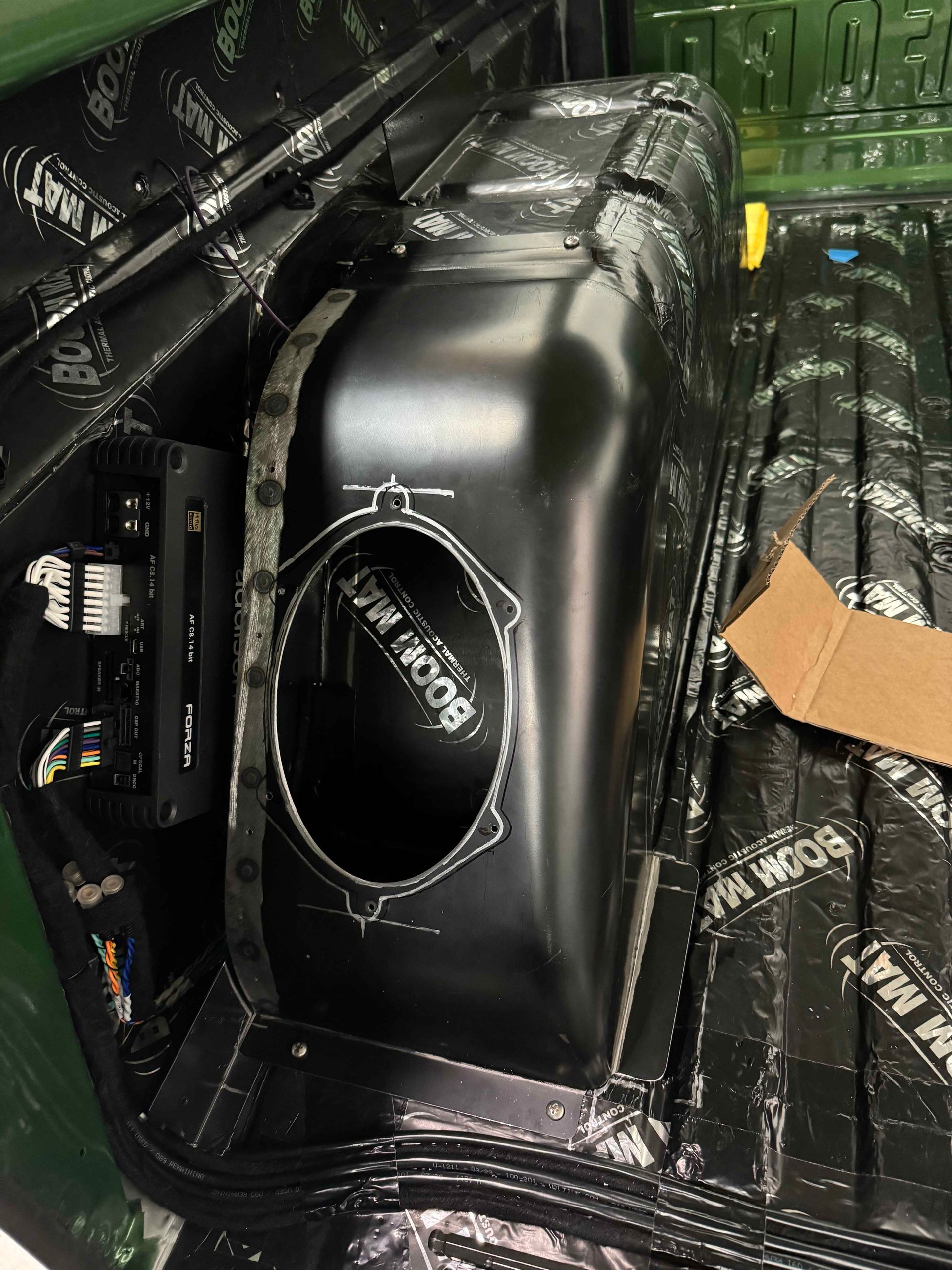 A subwoofer is sitting in the back of a truck.