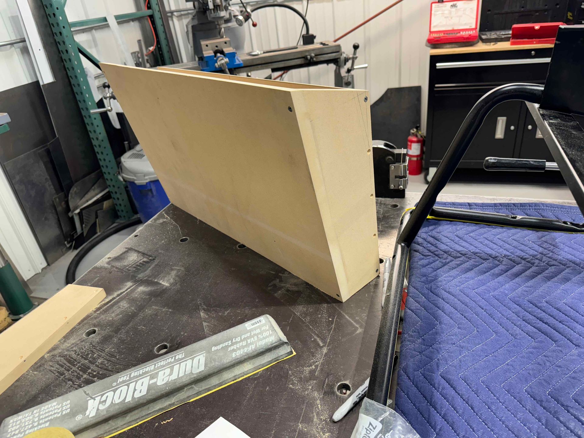 A piece of wood is sitting on top of a table in a garage.