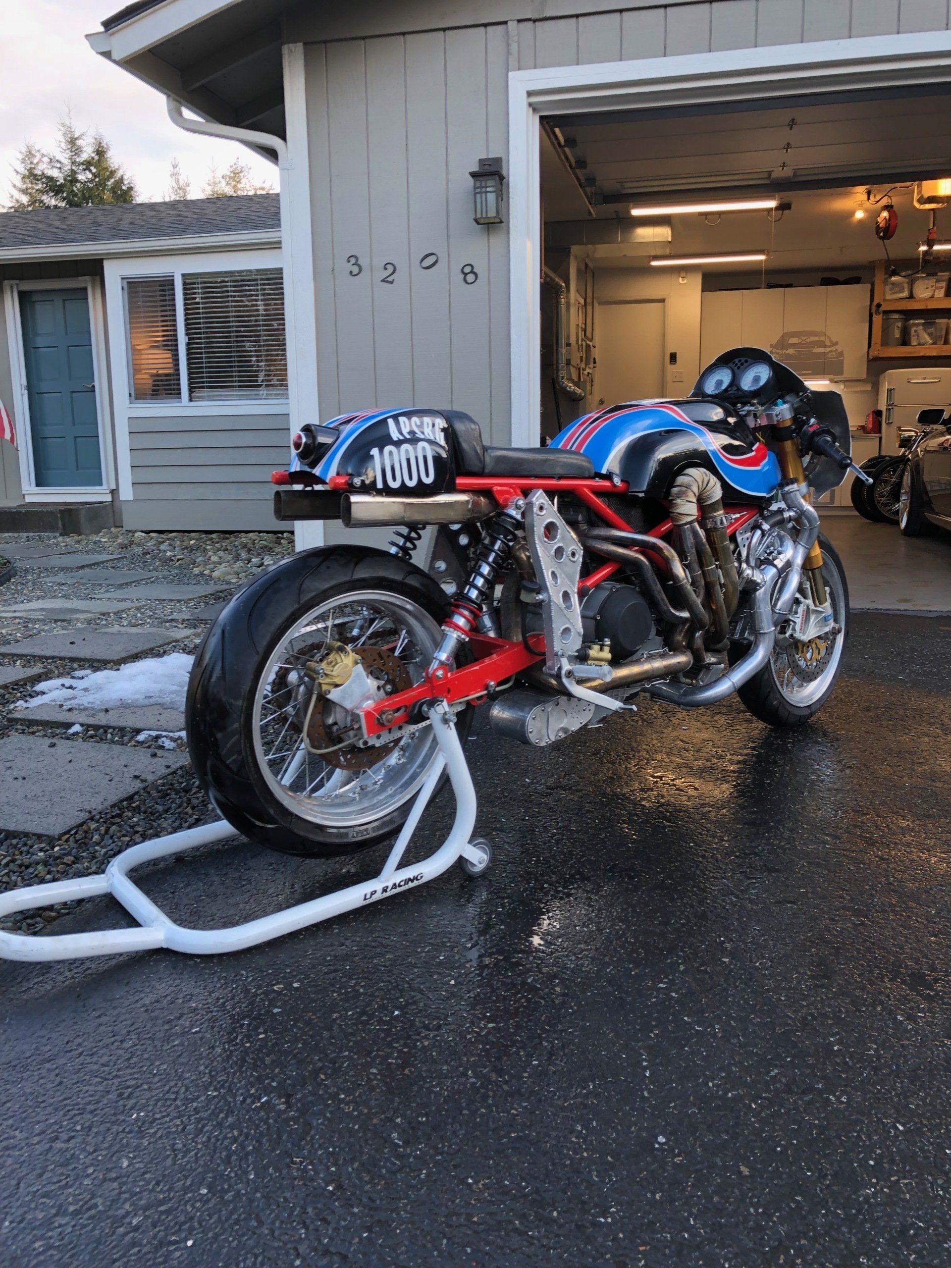 A motorcycle is parked in front of a garage.