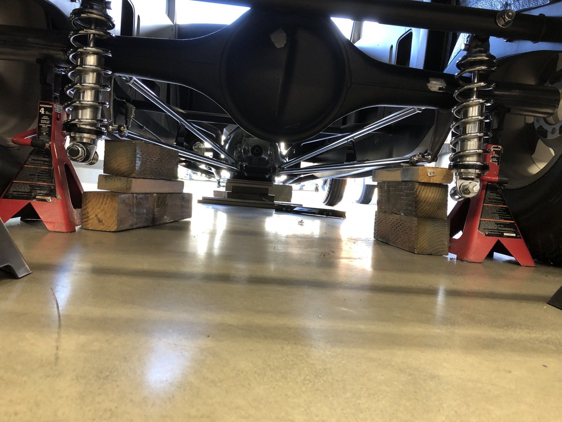 The rear end of a truck is sitting on jack stands