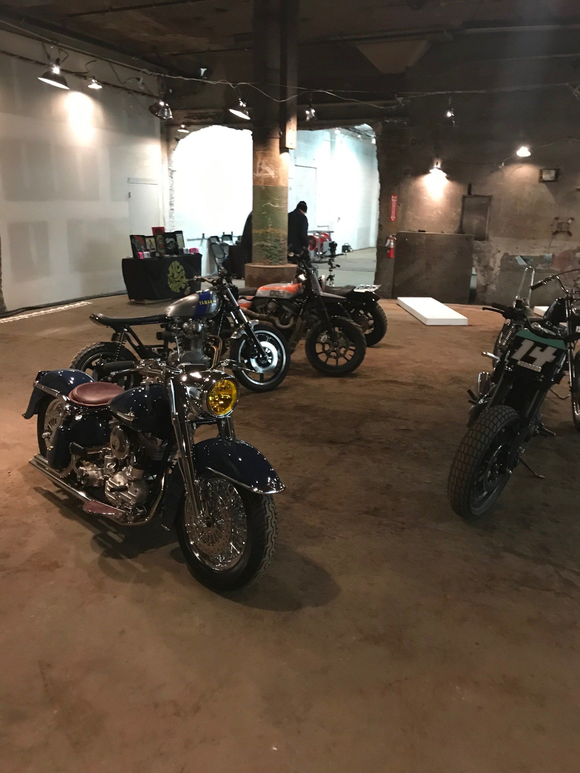 A row of motorcycles are parked in a room with the number 14 on the back