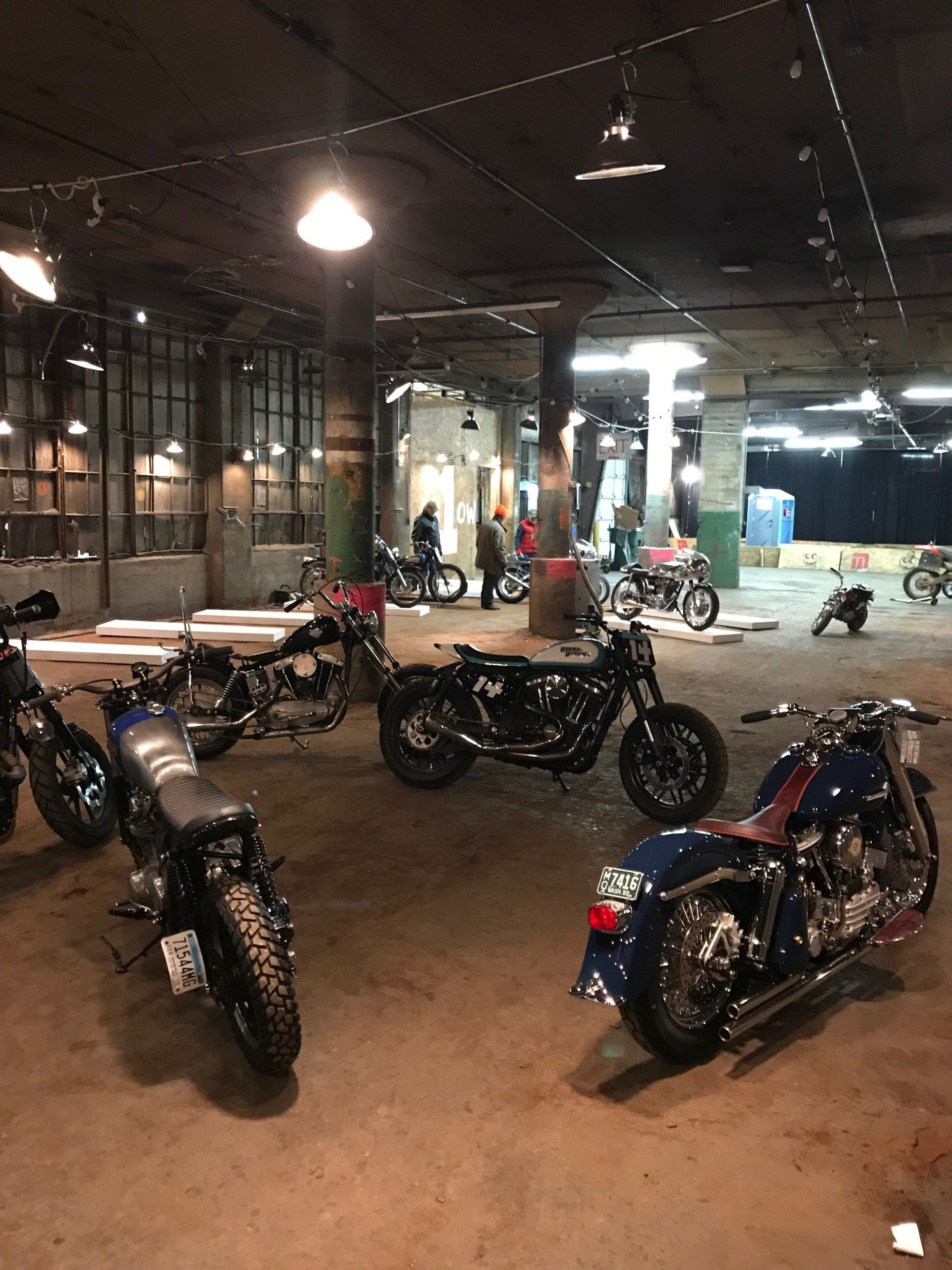 A group of motorcycles are parked in a garage.