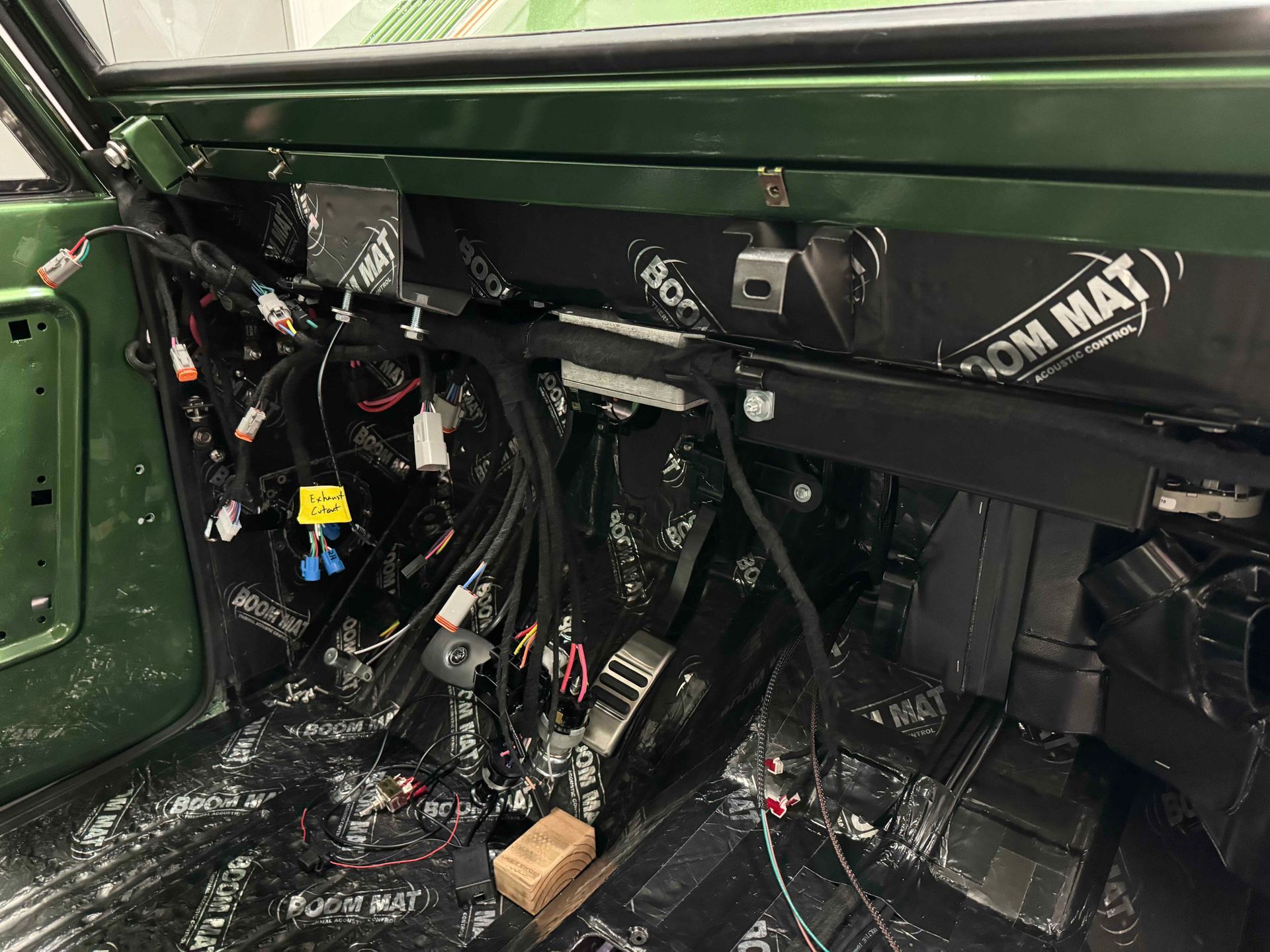 A green car with a lot of wires coming out of it.