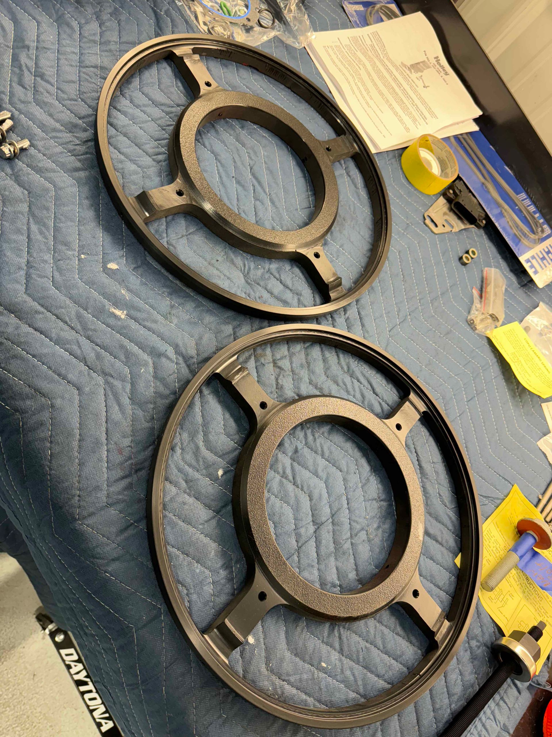 A pair of speaker covers are sitting on top of a blue blanket.