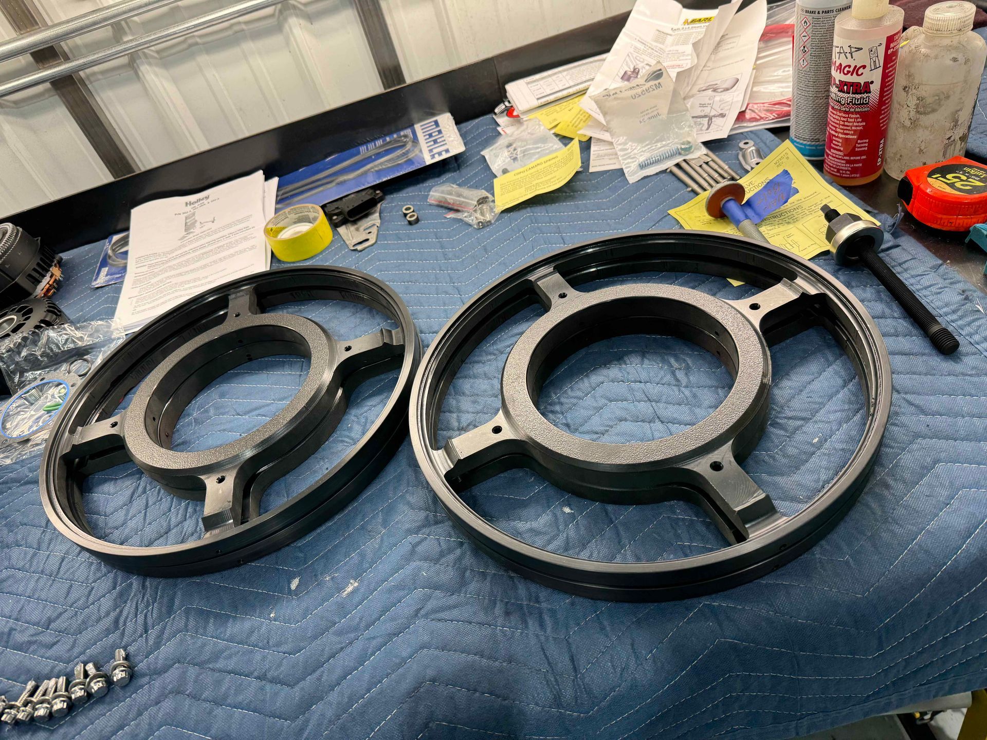 Two wheels are sitting on a blue blanket on a table.