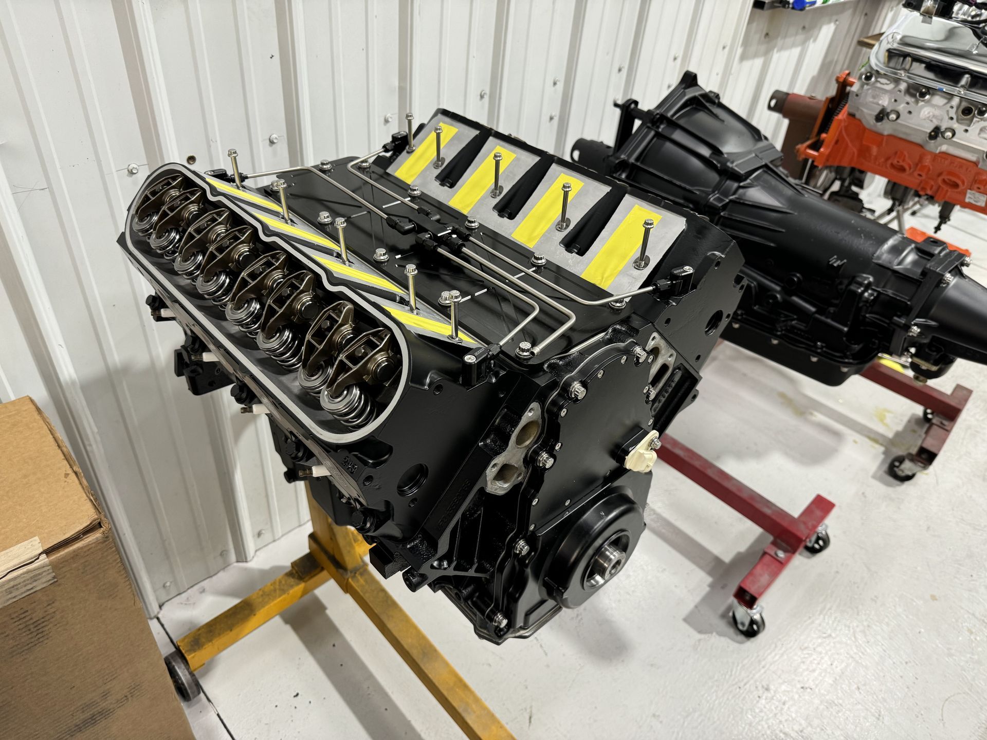 A black and yellow engine is sitting on a stand in a garage.