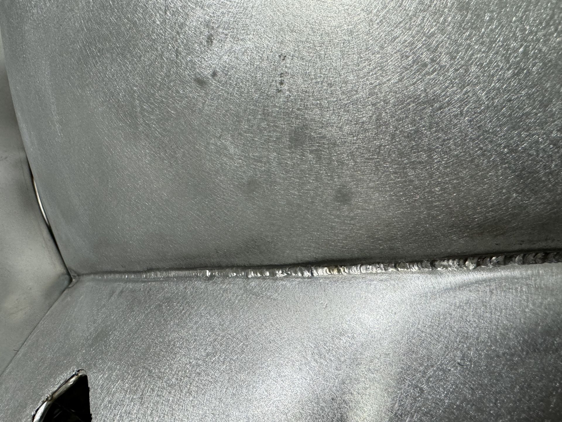 A close up of a metal surface with a corner.