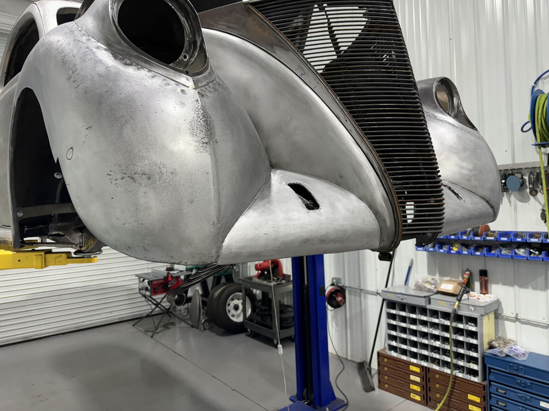 A car is sitting on a lift in a garage.