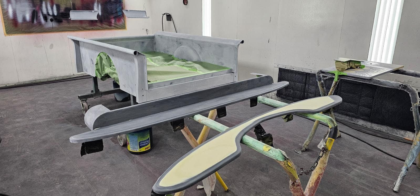 A car is being painted in a garage.