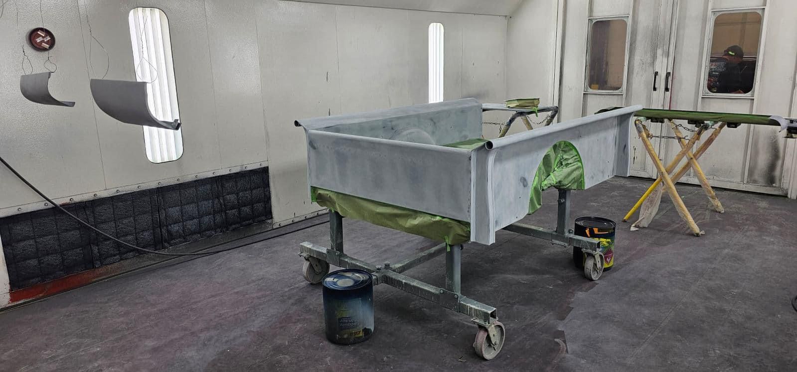 A car is being painted in a paint booth.