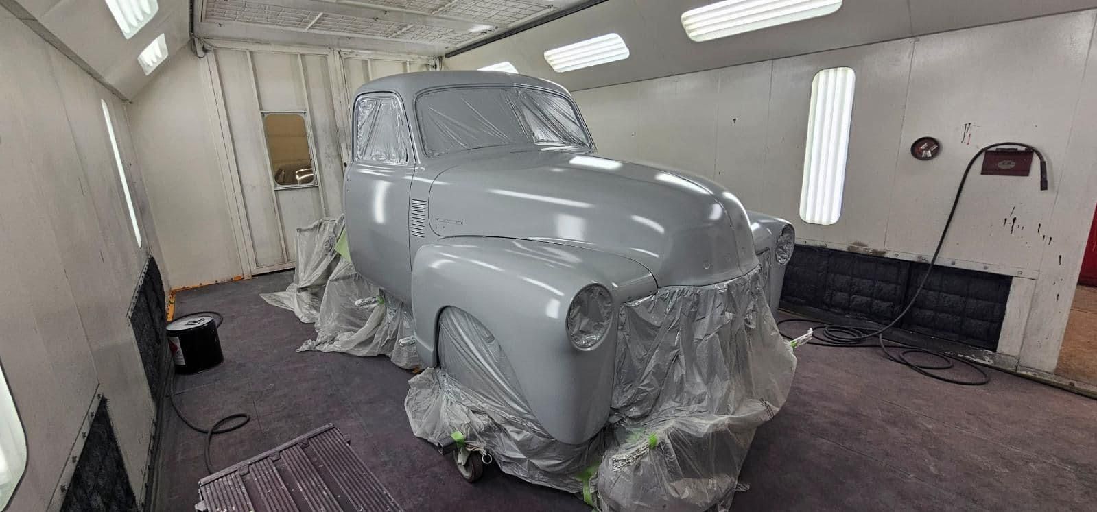 A car is being painted in a paint booth.