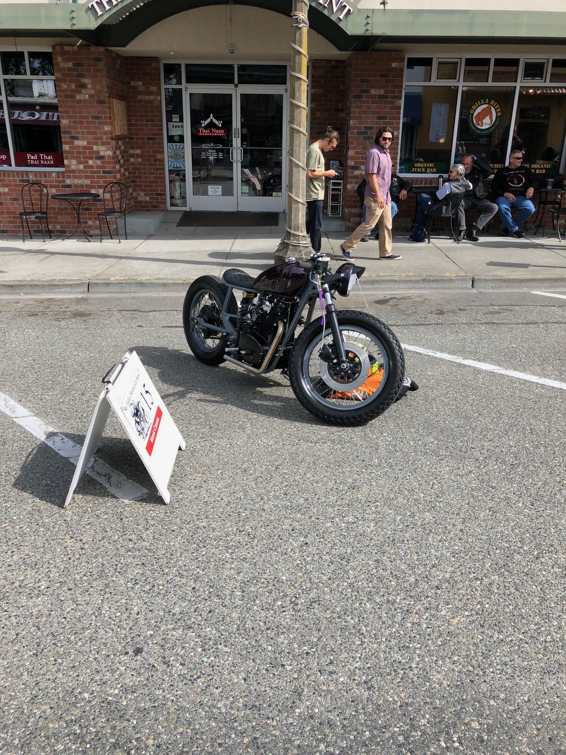 A motorcycle is parked in a parking lot in front of a building.
