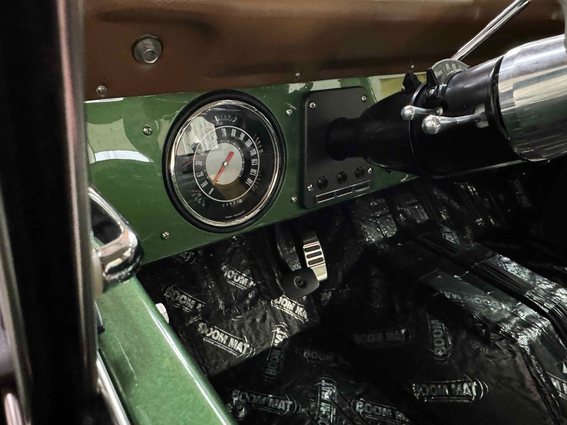 A green car with a speedometer and a steering wheel