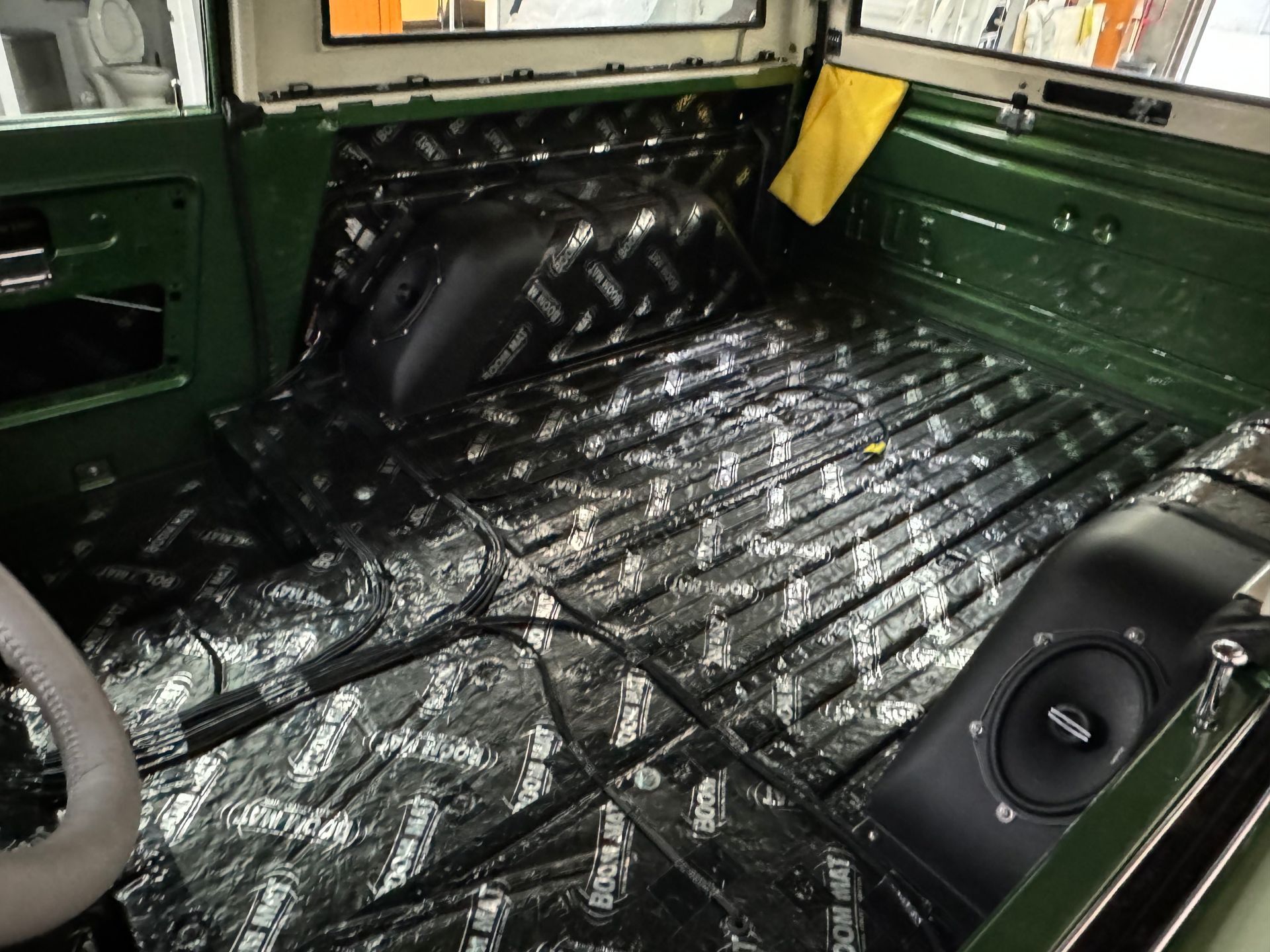 The inside of a green truck with a speaker in the back