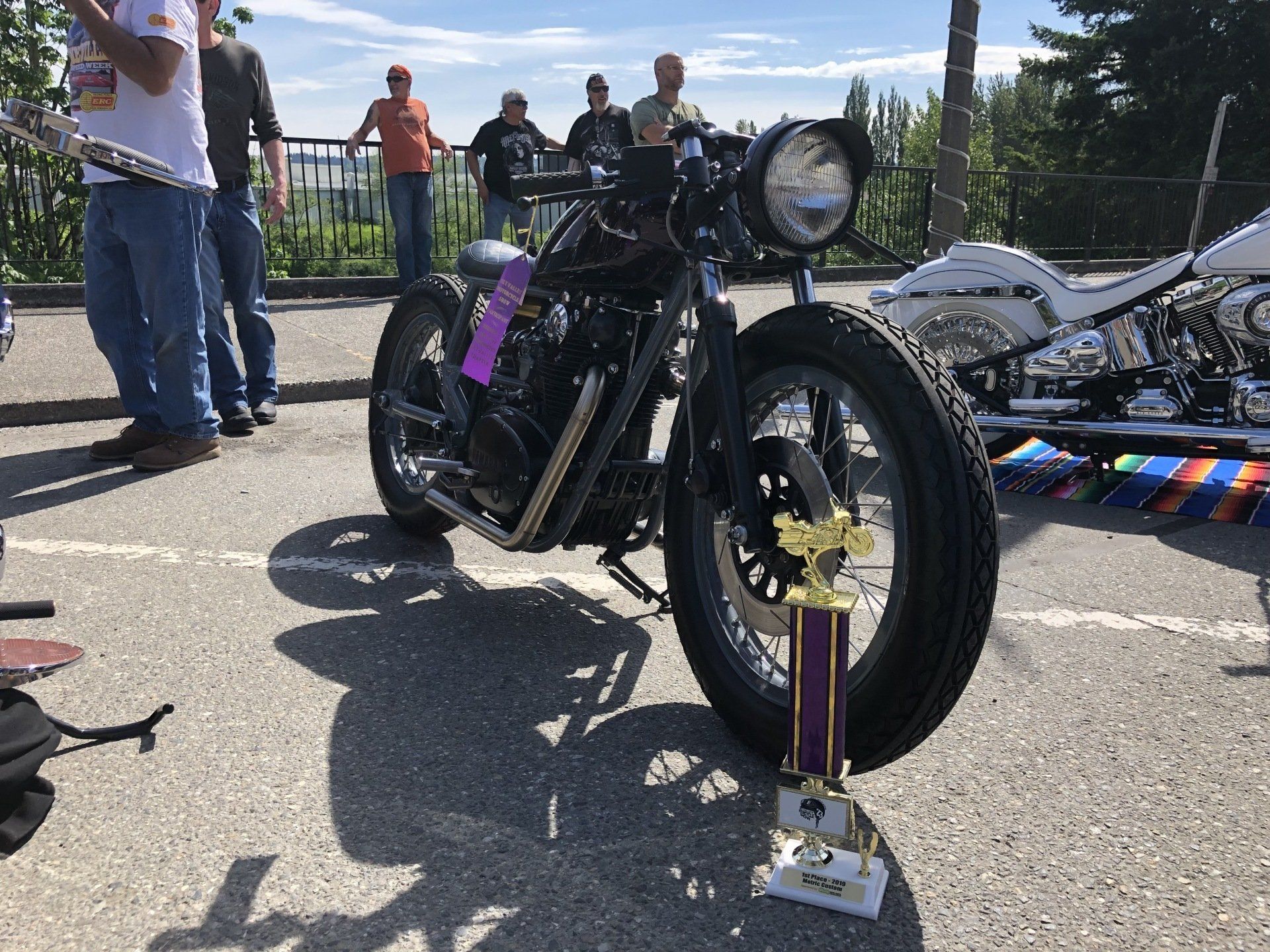 A motorcycle with a trophy on it is parked in a parking lot.