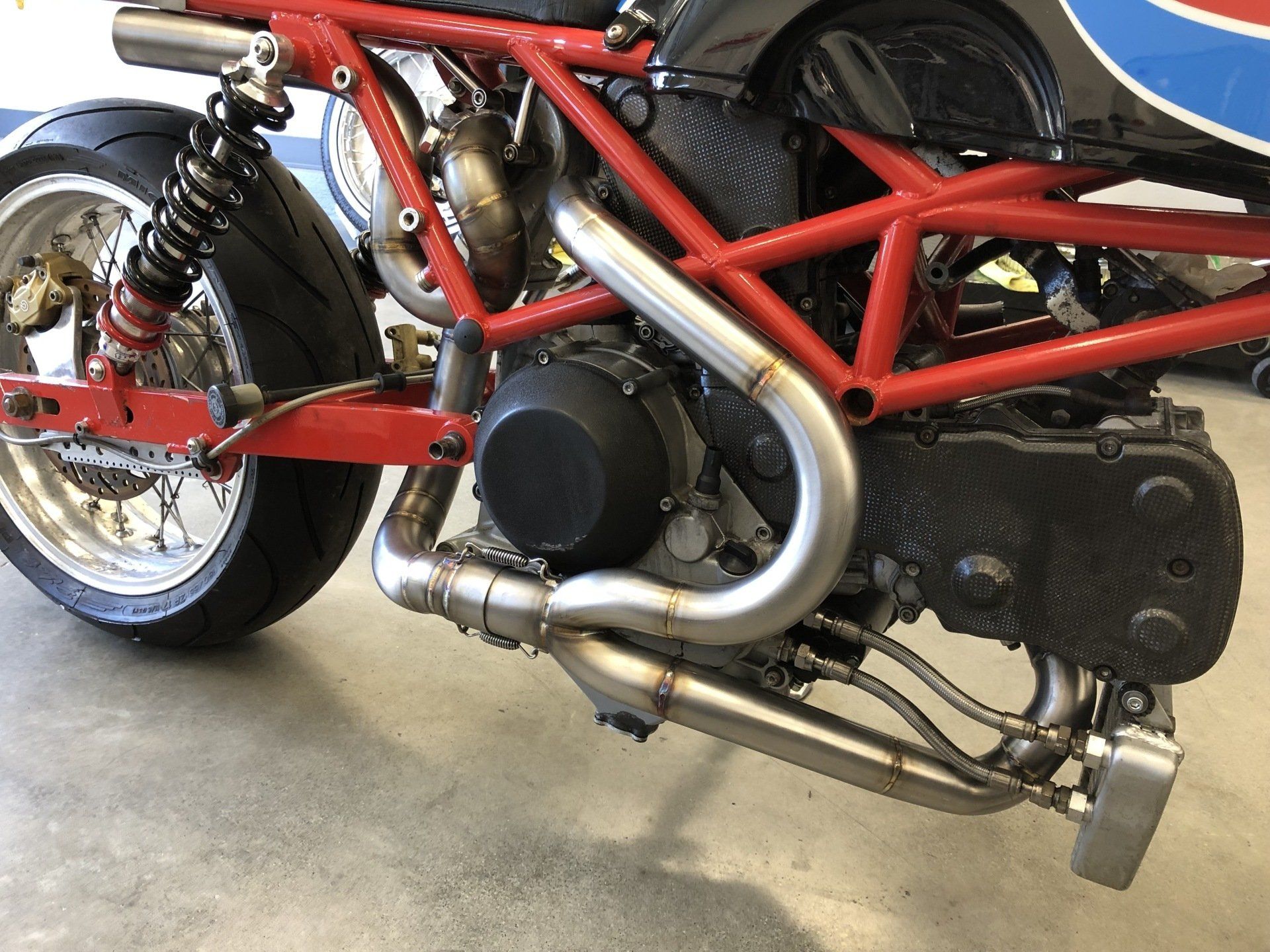 A red and blue motorcycle is parked in a garage