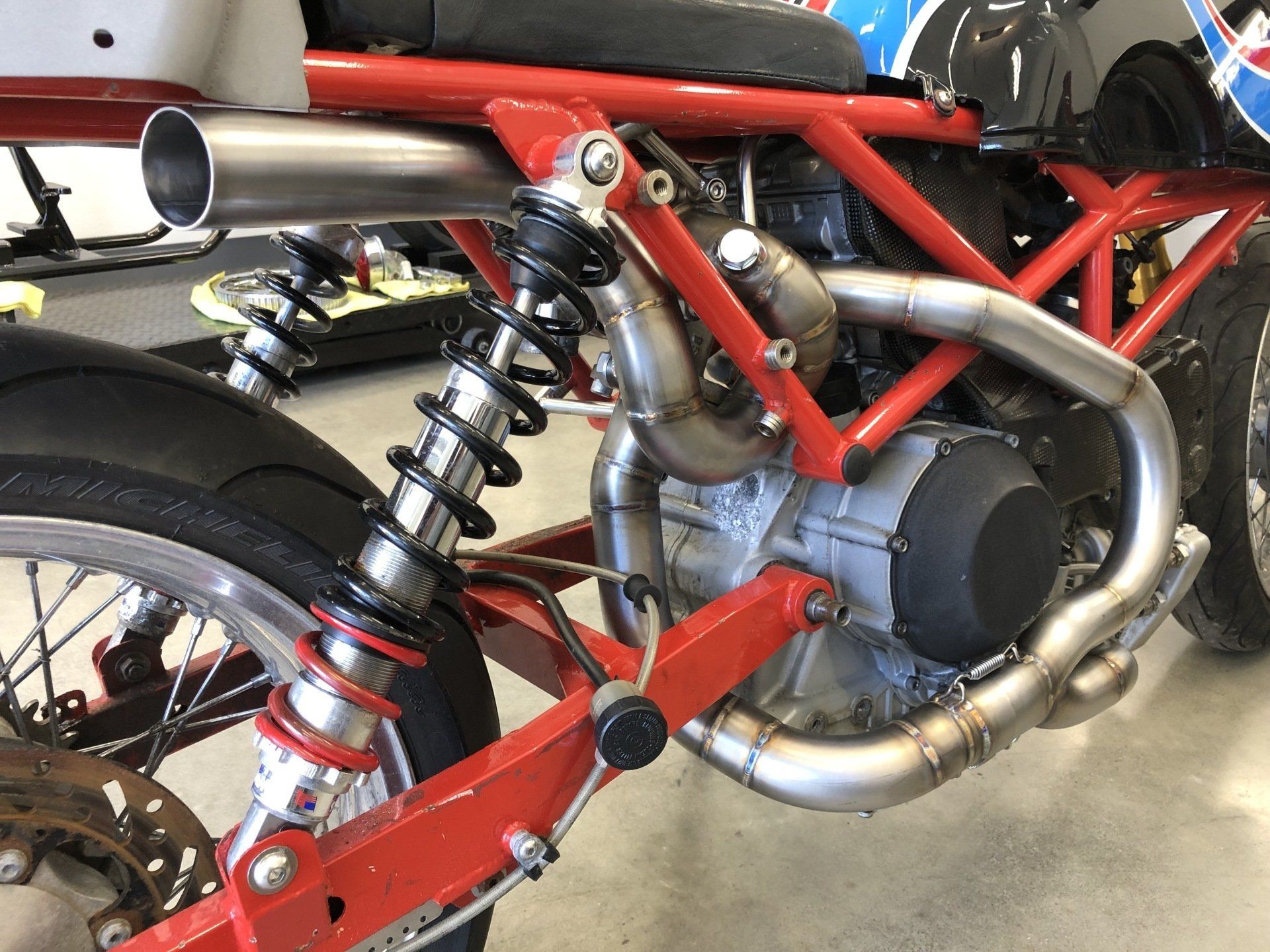 A close up of a motorcycle engine and exhaust pipe