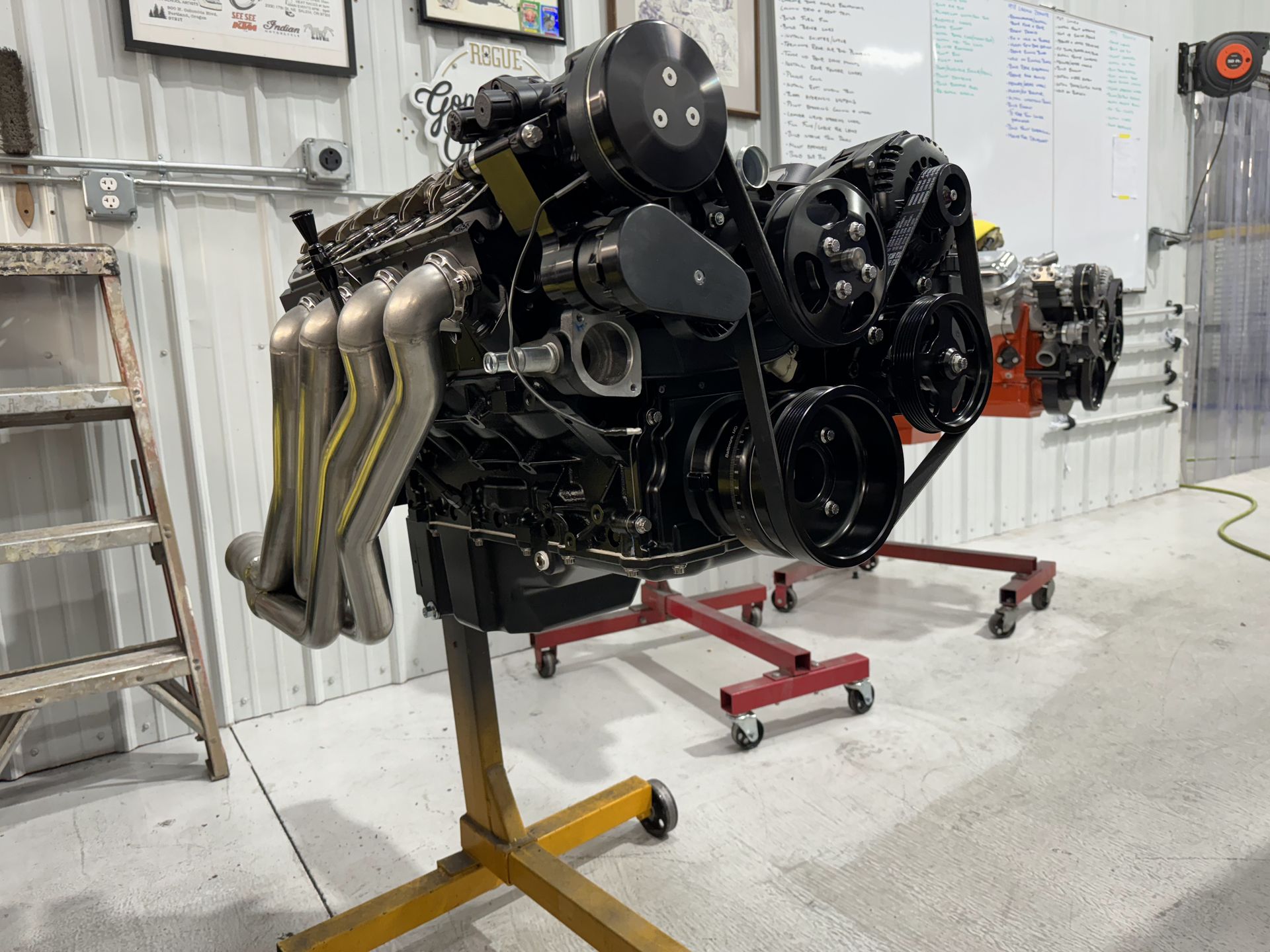 A large engine is sitting on a stand in a garage.