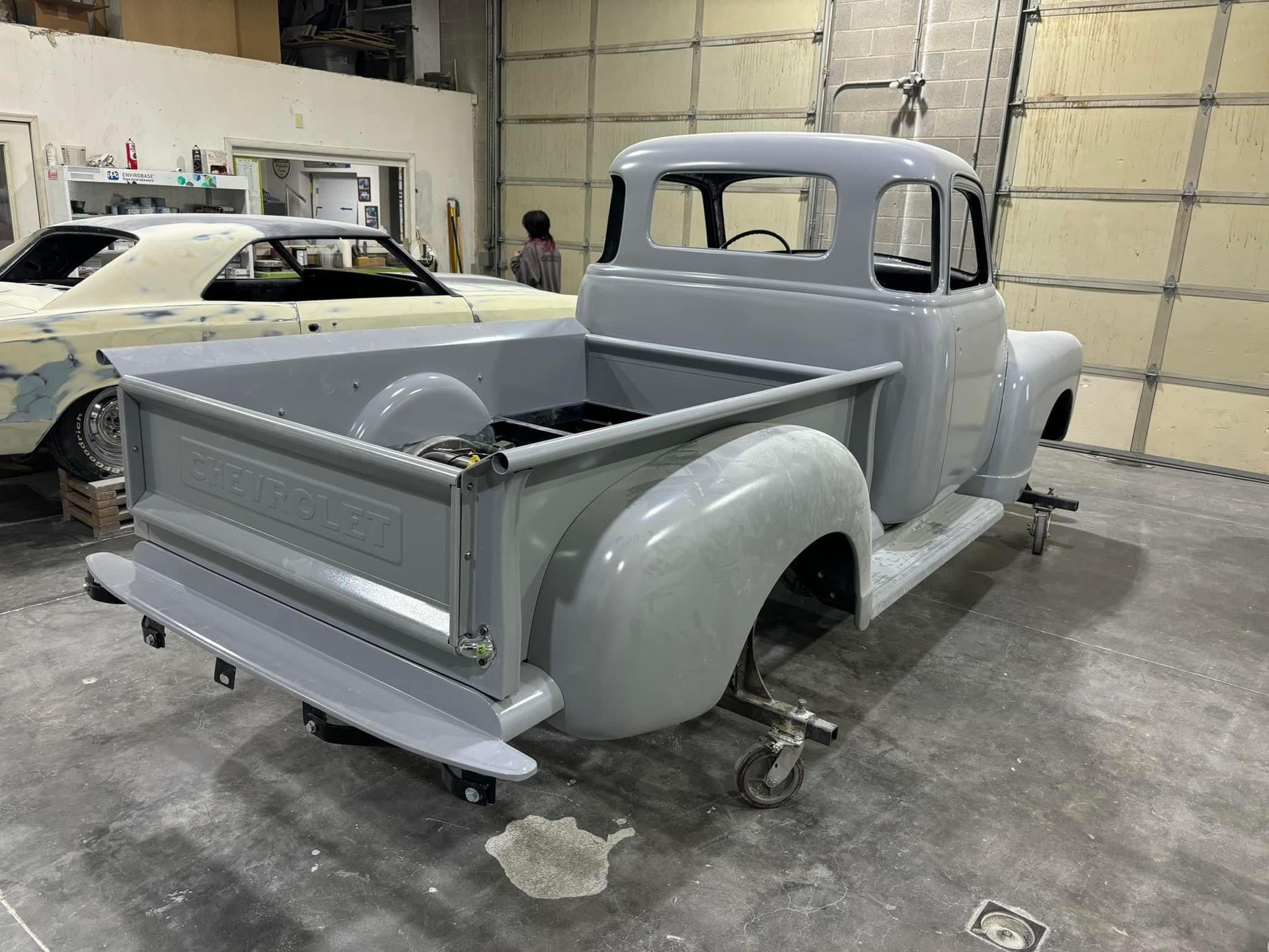 A truck is sitting on a cart in a garage.